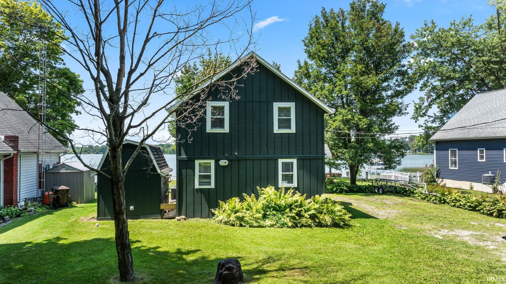 Dark green board-and-batten exterior with white trim and multi-pane windows