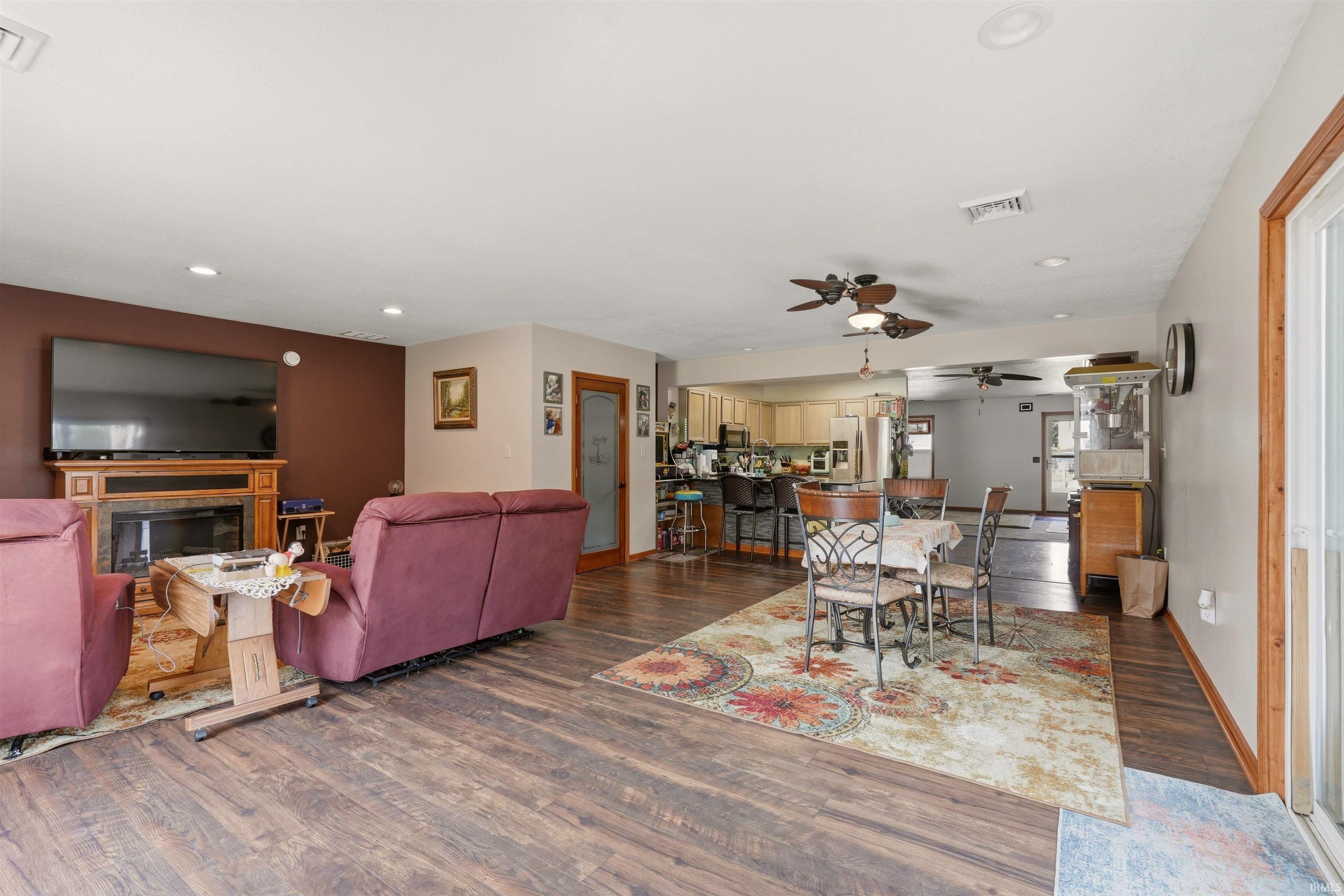 Wood-finish flooring throughout, recessed lighting, and a built-in fireplace with a wood mantel