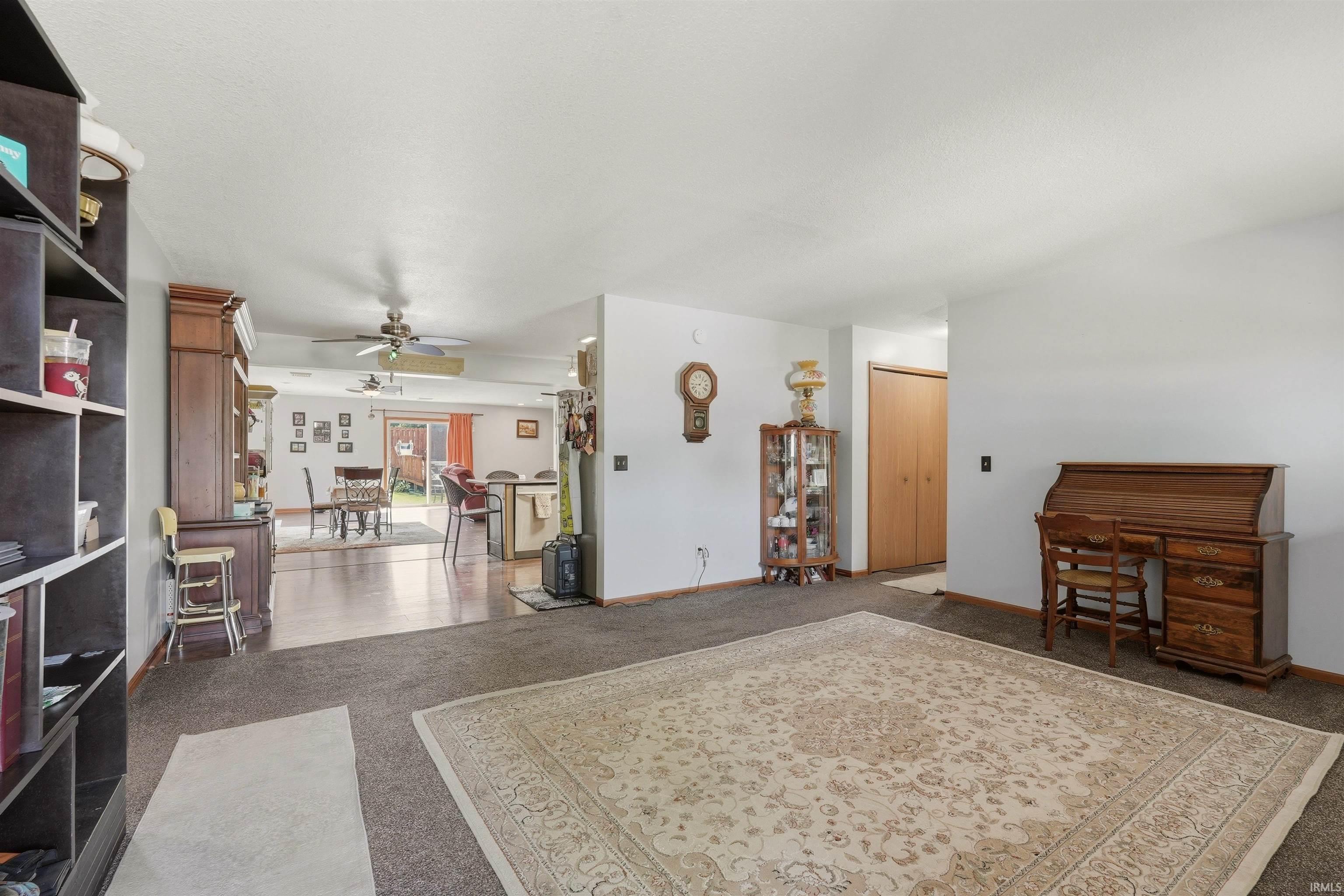 Carpeted flooring, white walls, and a built-in shelving unit