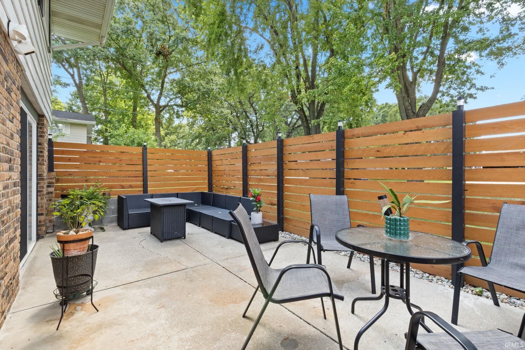 Paved patio area with a slatted privacy fence