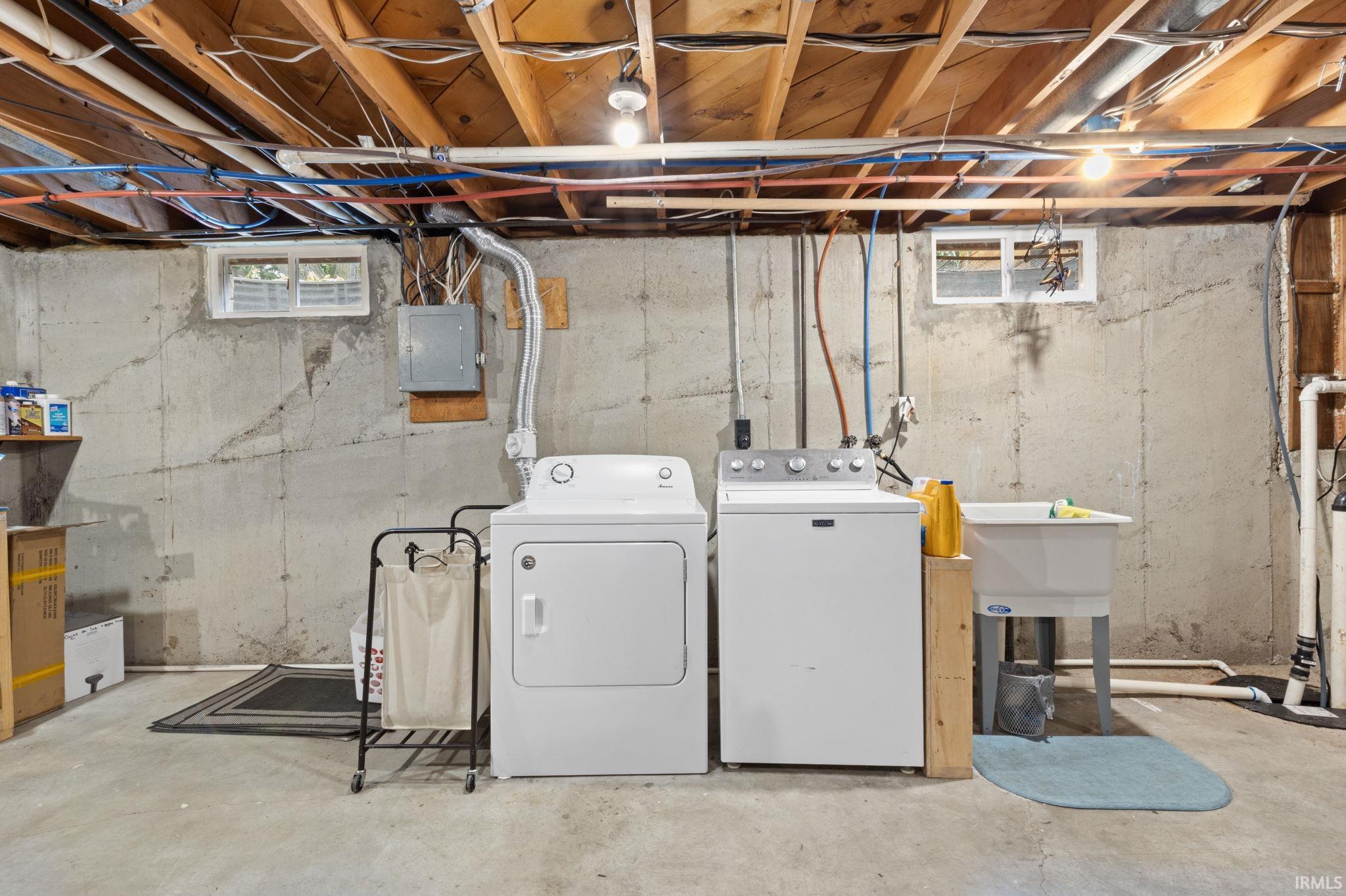Utility area featuring a washer, dryer, and a utility sink