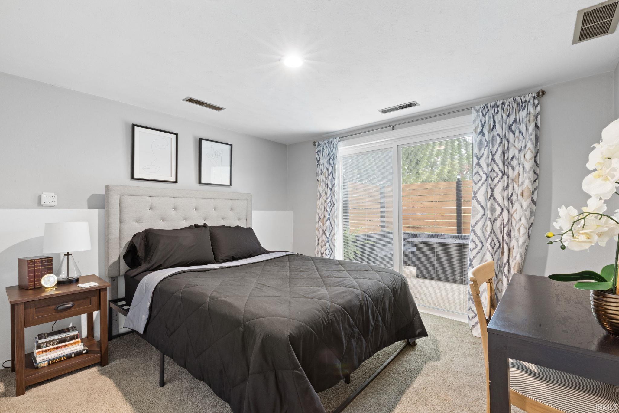 Recessed ceiling lighting, carpeted flooring, sliding glass door, private patio, and a privacy fence