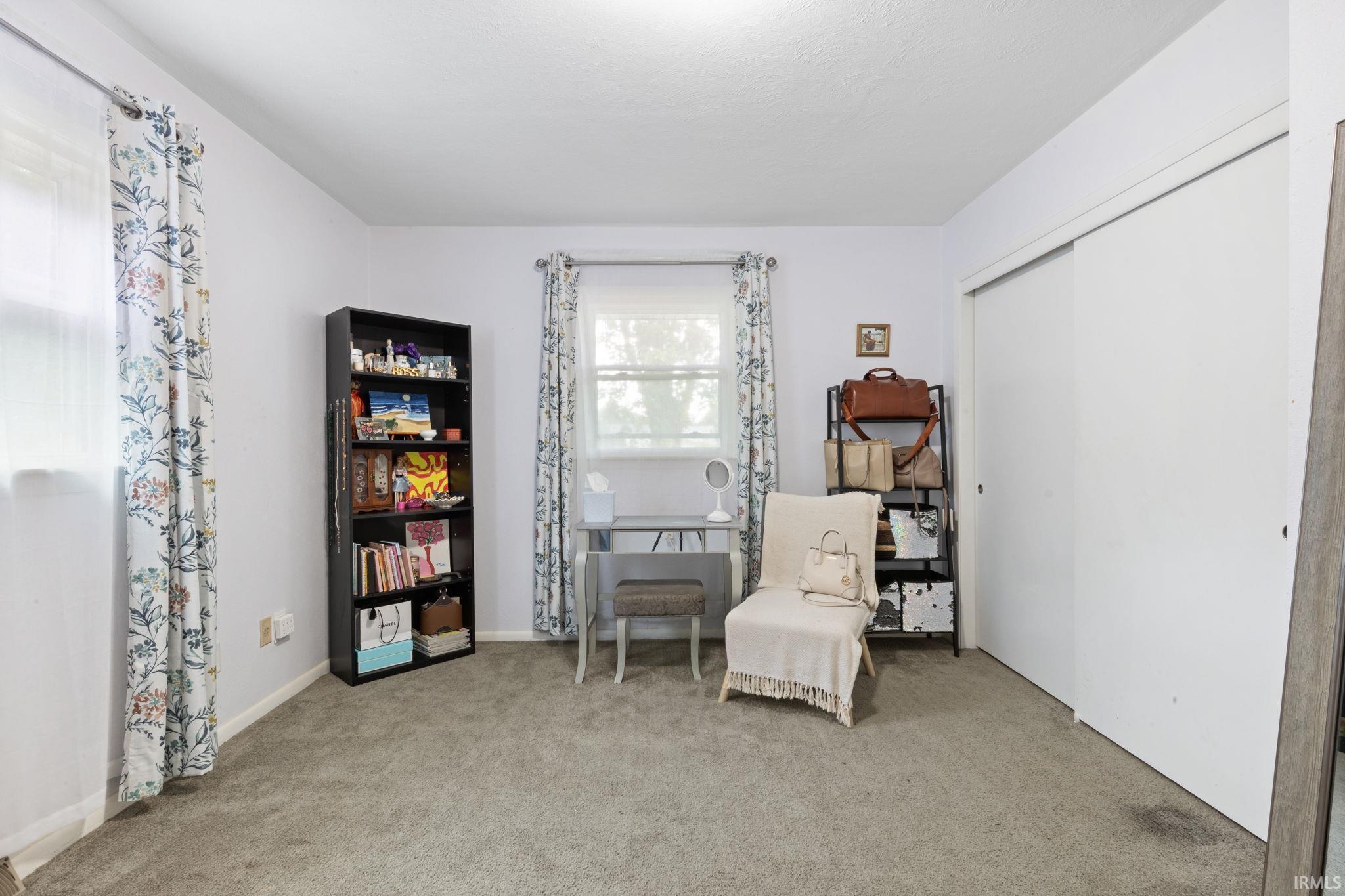 Sliding closet doors, wall-to-wall carpeting, and multiple windows with natural light