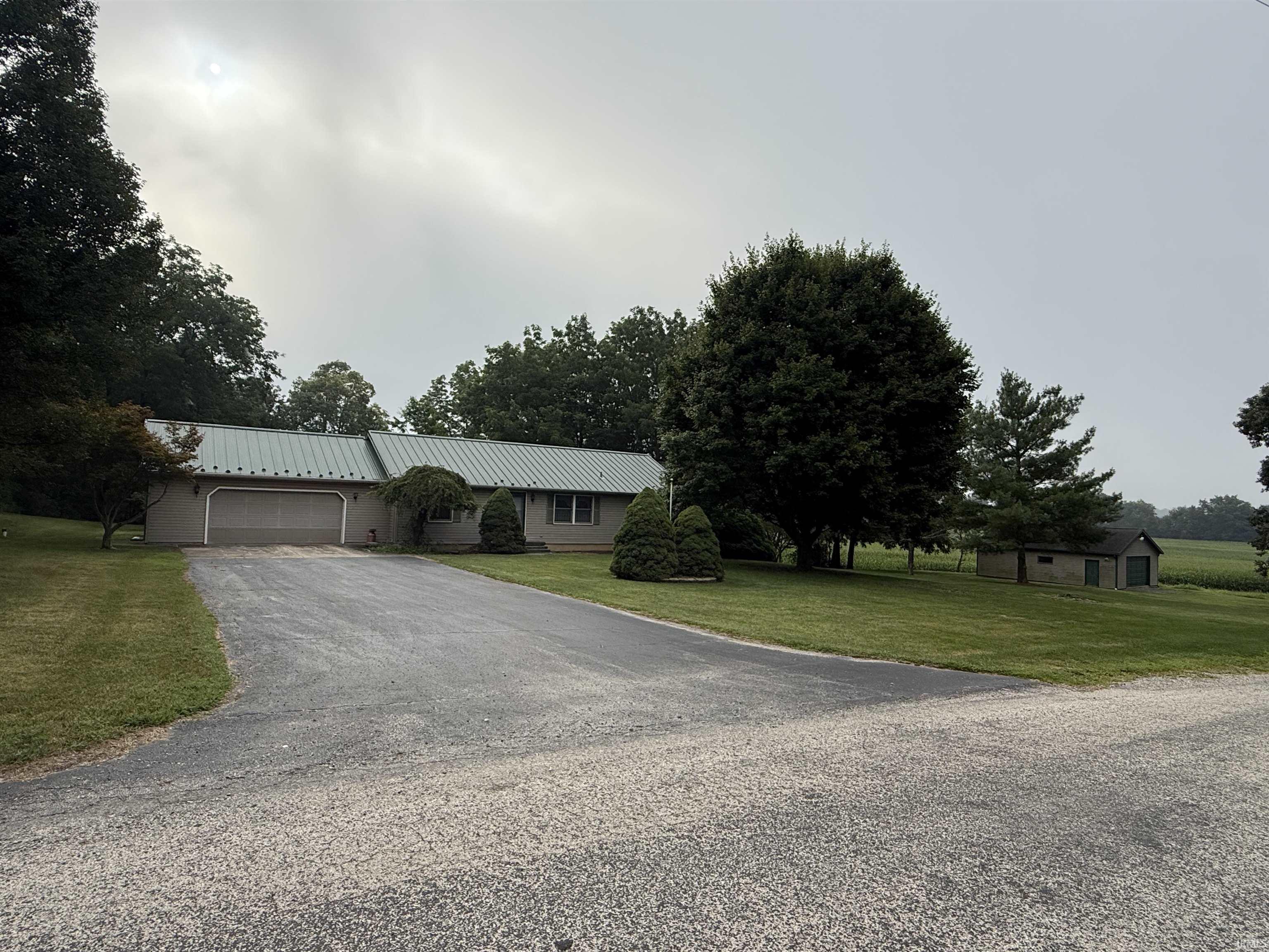 Don't miss your opportunity to own this well-maintained ranch home nestled on 2 scenic acres surrounded by beautiful mature trees. This property offers the perfect blend of peaceful country living and endless potential.  Inside, you'll find an open kitchen and dining area that's ideal for everyday living and entertaining, along with a spacious laundry room for added convenience. The home also features a crawl space for easy access to utilities.  The durable metal roof was replaced approximately 12 years ago, providing added peace of mind. Outside, you'll love the impressive detached garage/shop complete with a half bath—perfect for hobbies, storage, projects, or a workshop. With plenty of room to make it your own, this property is ready for its next owner to enjoy!