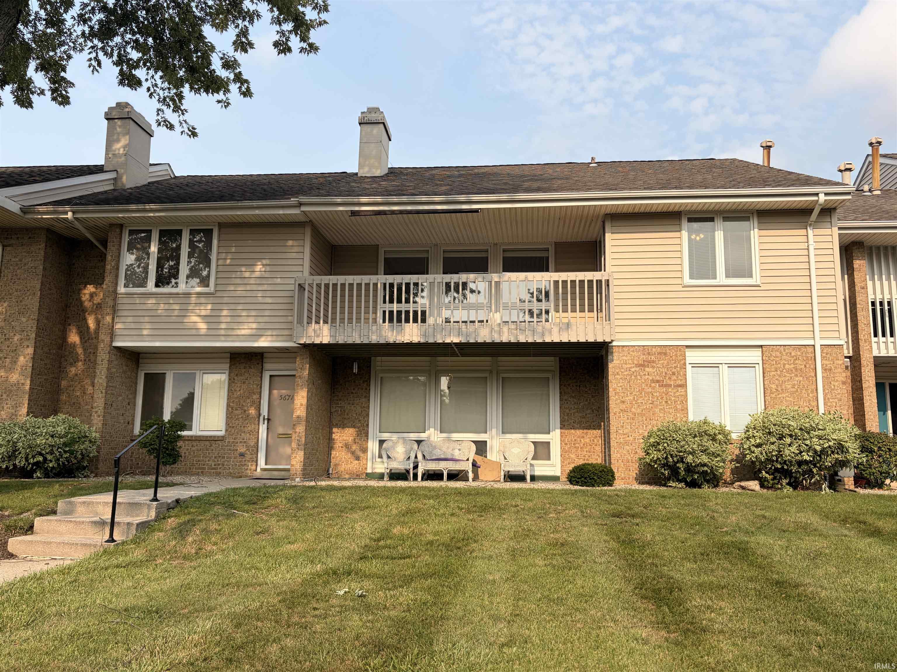 Brick and siding exterior featuring a second-story balcony