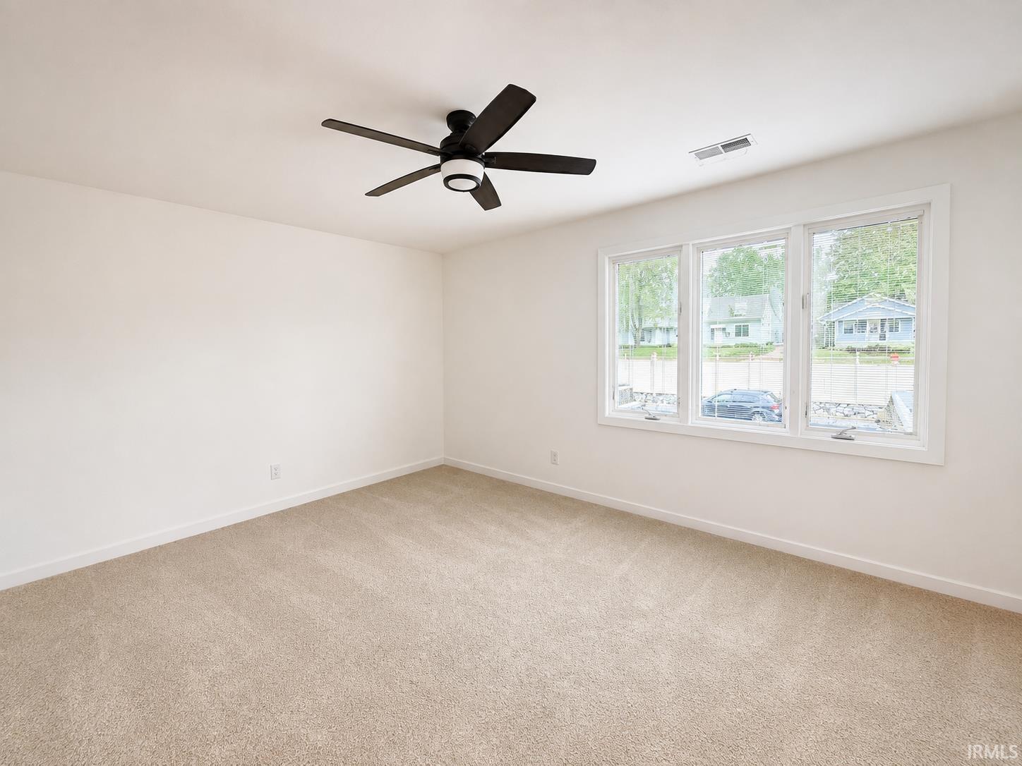 Neutral-toned carpeting, white walls, and a contemporary ceiling fan with integrated lighting