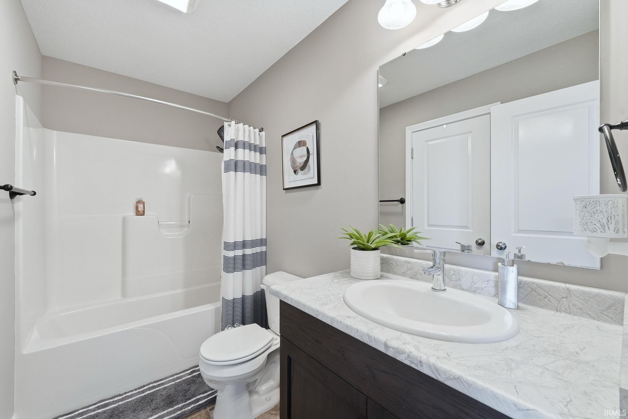 Vanity with an integrated oval sink, chrome faucet, and stone-finish countertop
