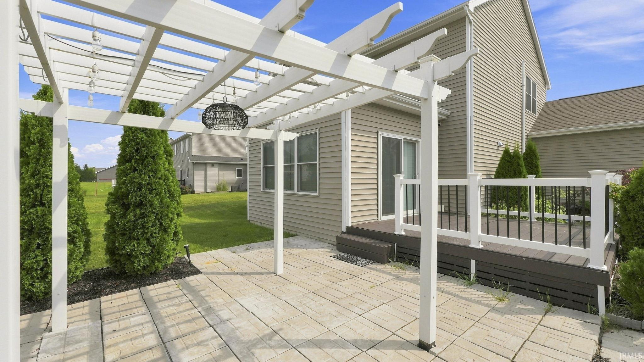 Patio with a pergola, paver flooring, and a composite deck with white railings
