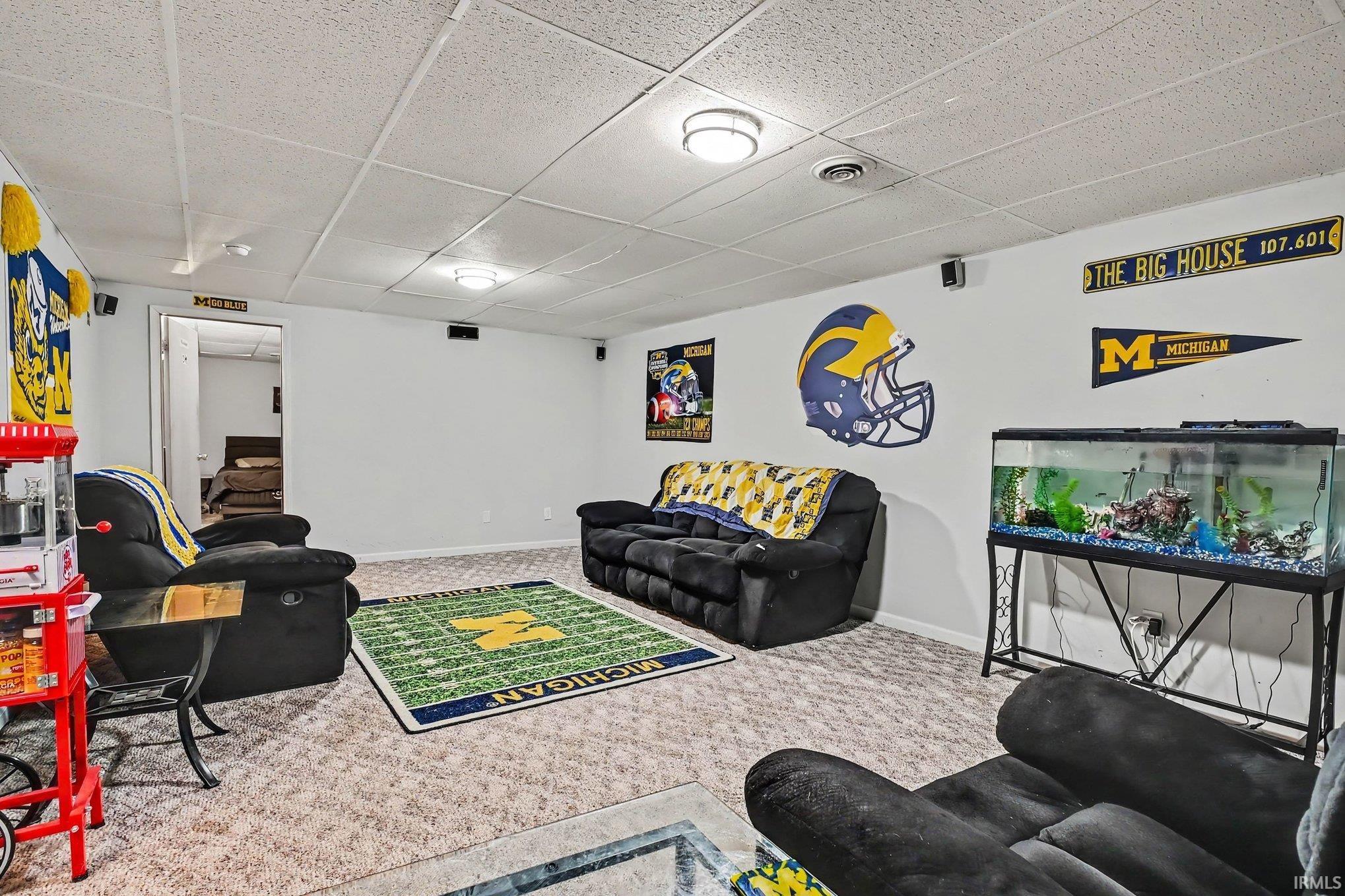 Finished lower level with neutral carpet and recessed lighting
