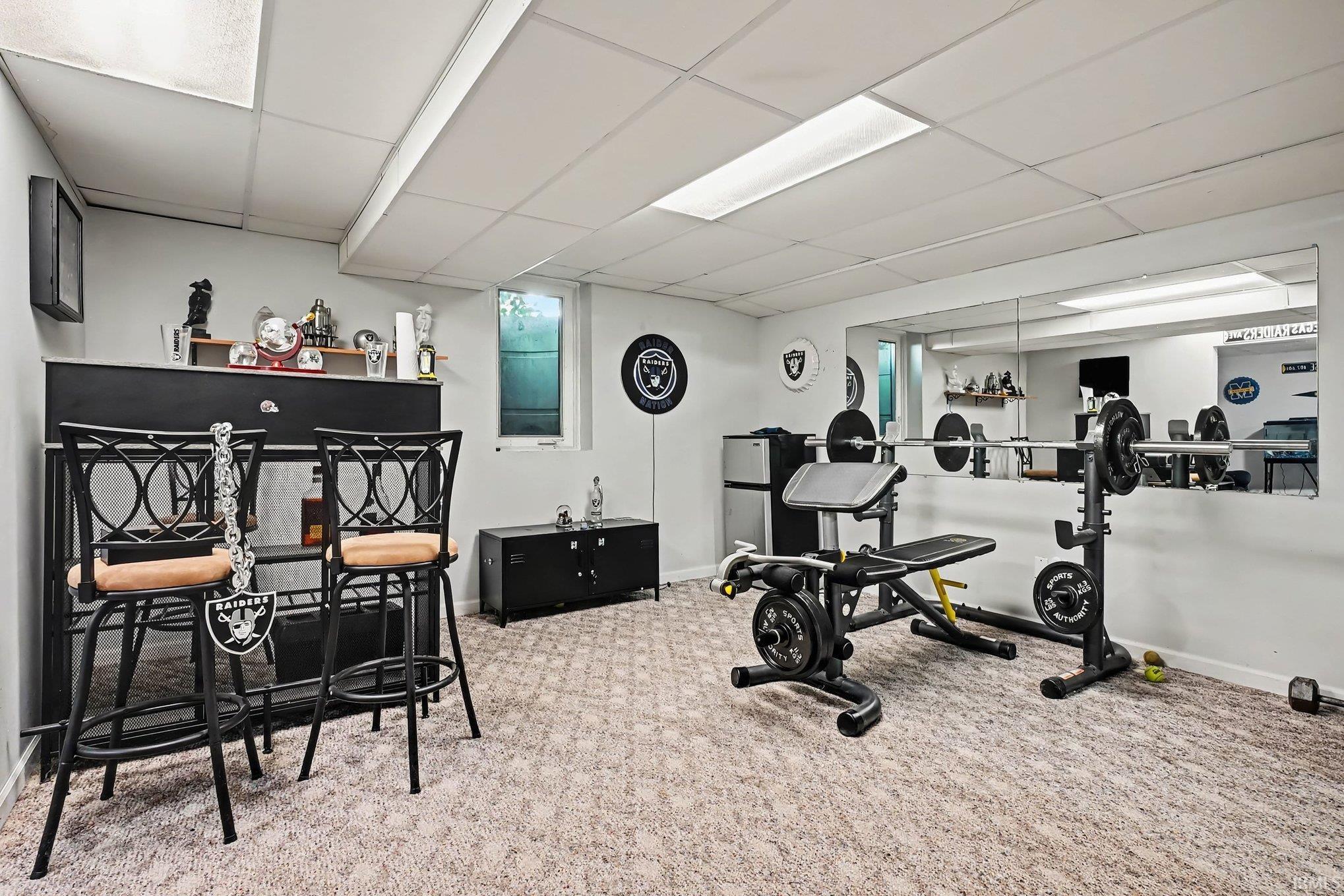Recessed ceiling lighting, full-wall mirror installation, and a built-in bar area