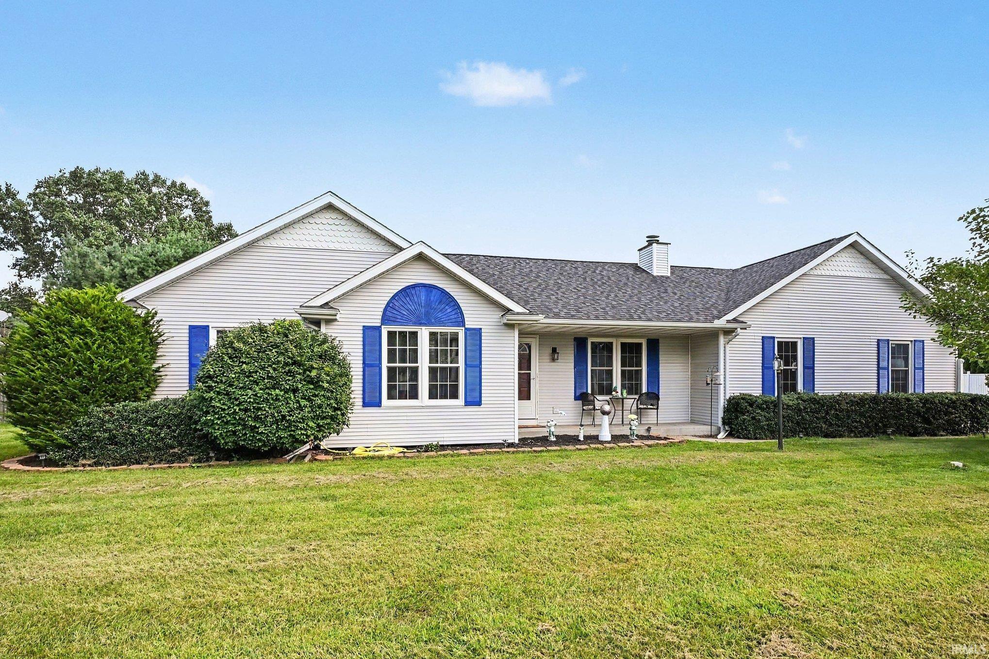 Ranch-style residence featuring light-colored siding, a dark shingled roof, and blue window shutters