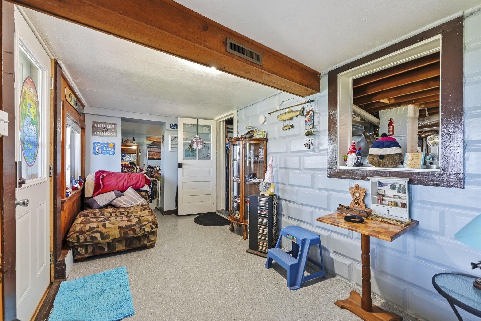 Exposed wood-finish ceiling beam, wood-finish window trim, and white paneled doors with clear glass inserts