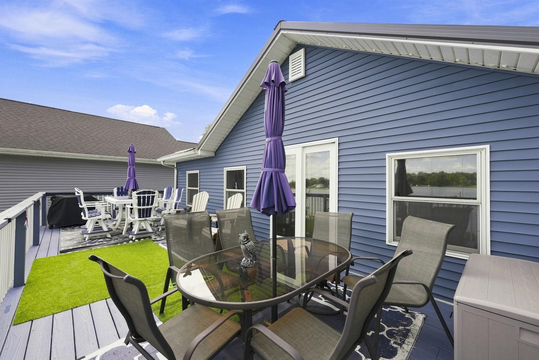 Expansive deck featuring blue siding, white railings, and a metal roof