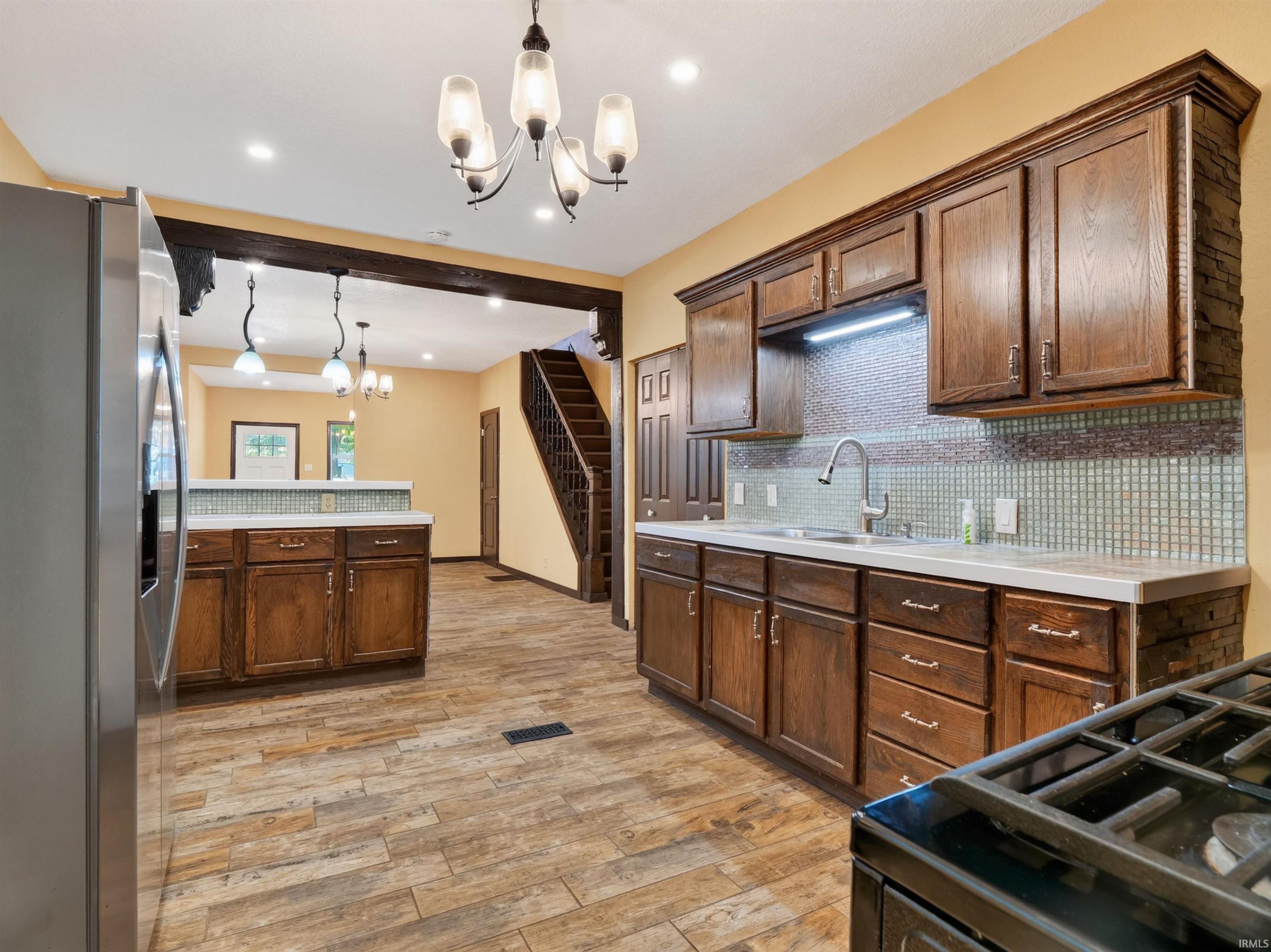 Kitchen featuring wood cabinetry, light-toned countertops, and a tiled backsplash