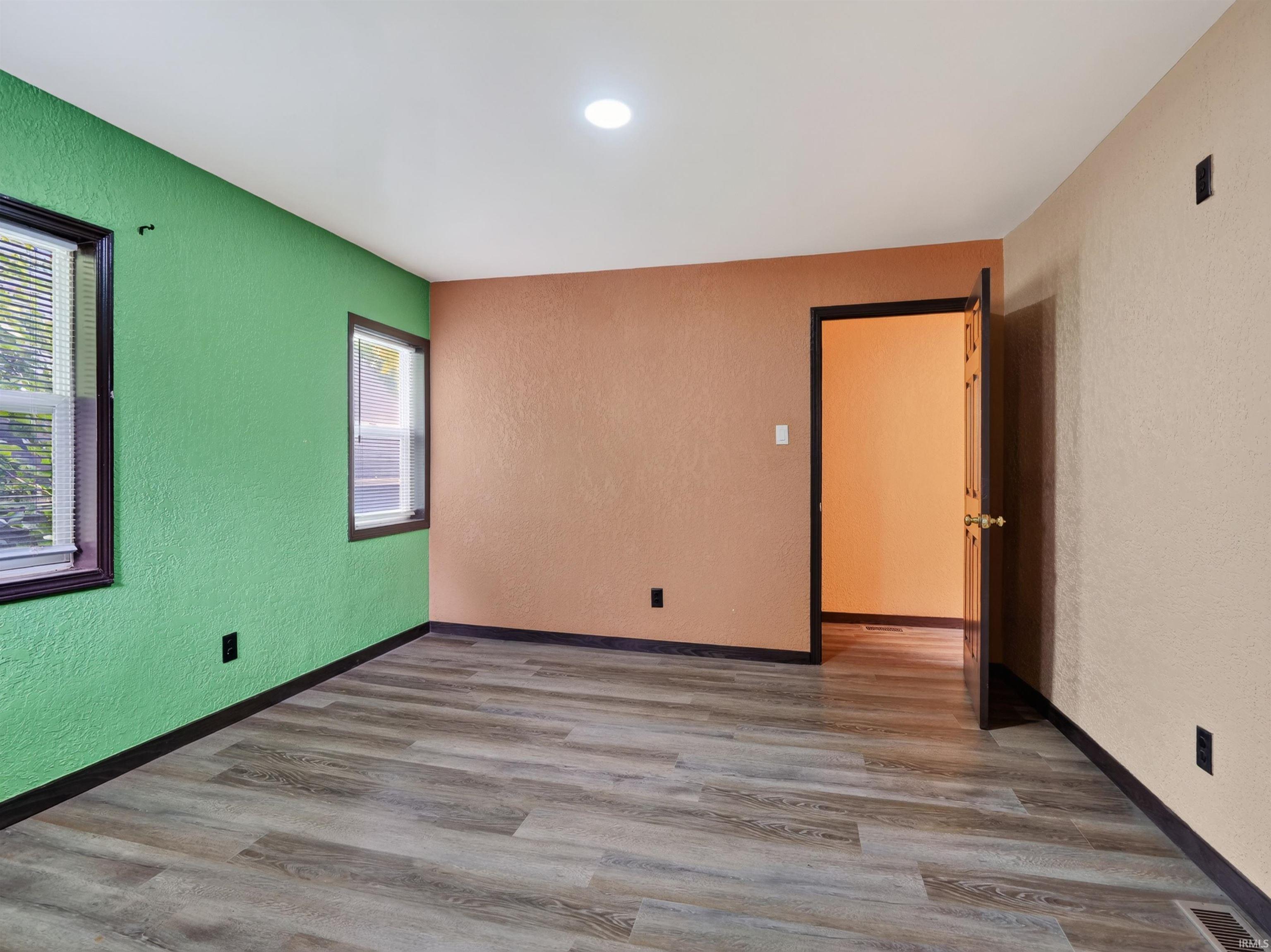 Wood-finish flooring with dark trim and recessed ceiling lighting