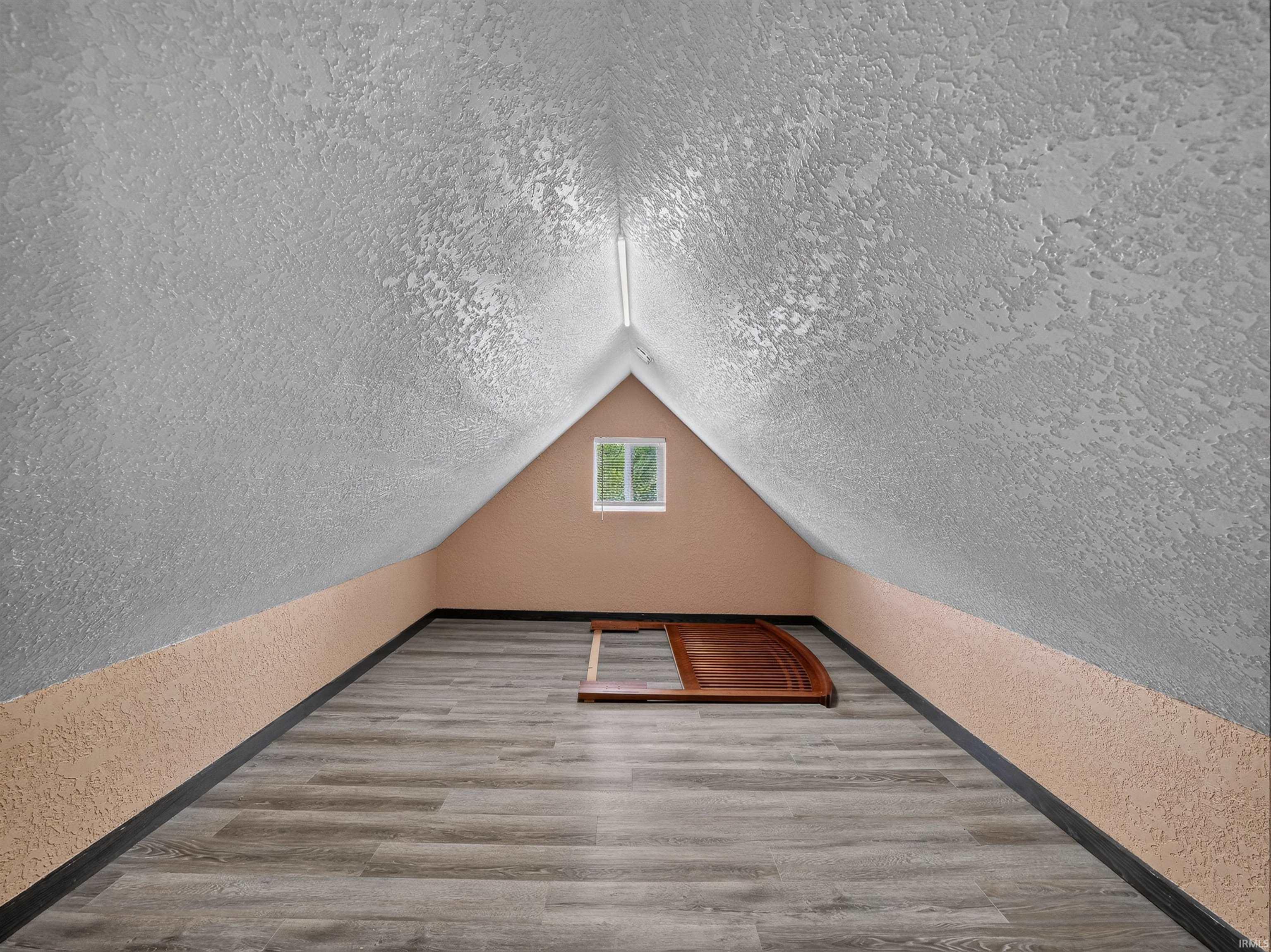 Window dormer with a centered double-hung window, sloped textured walls, and wood-finish flooring