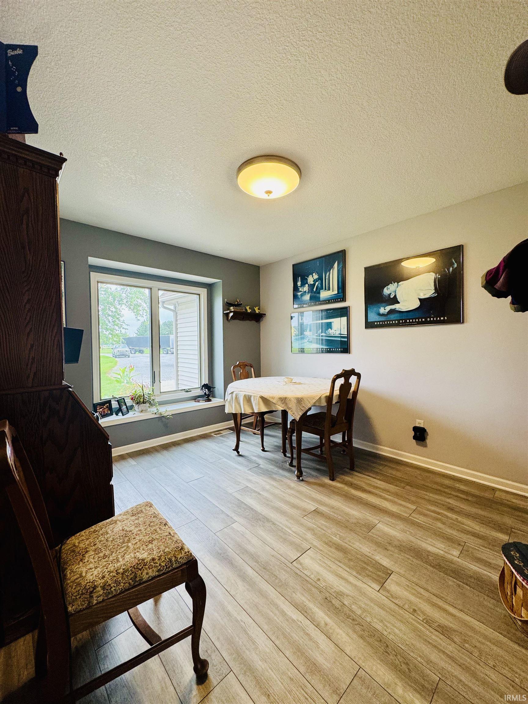 Wood-finish flooring throughout, paired with a large window featuring a deep sill