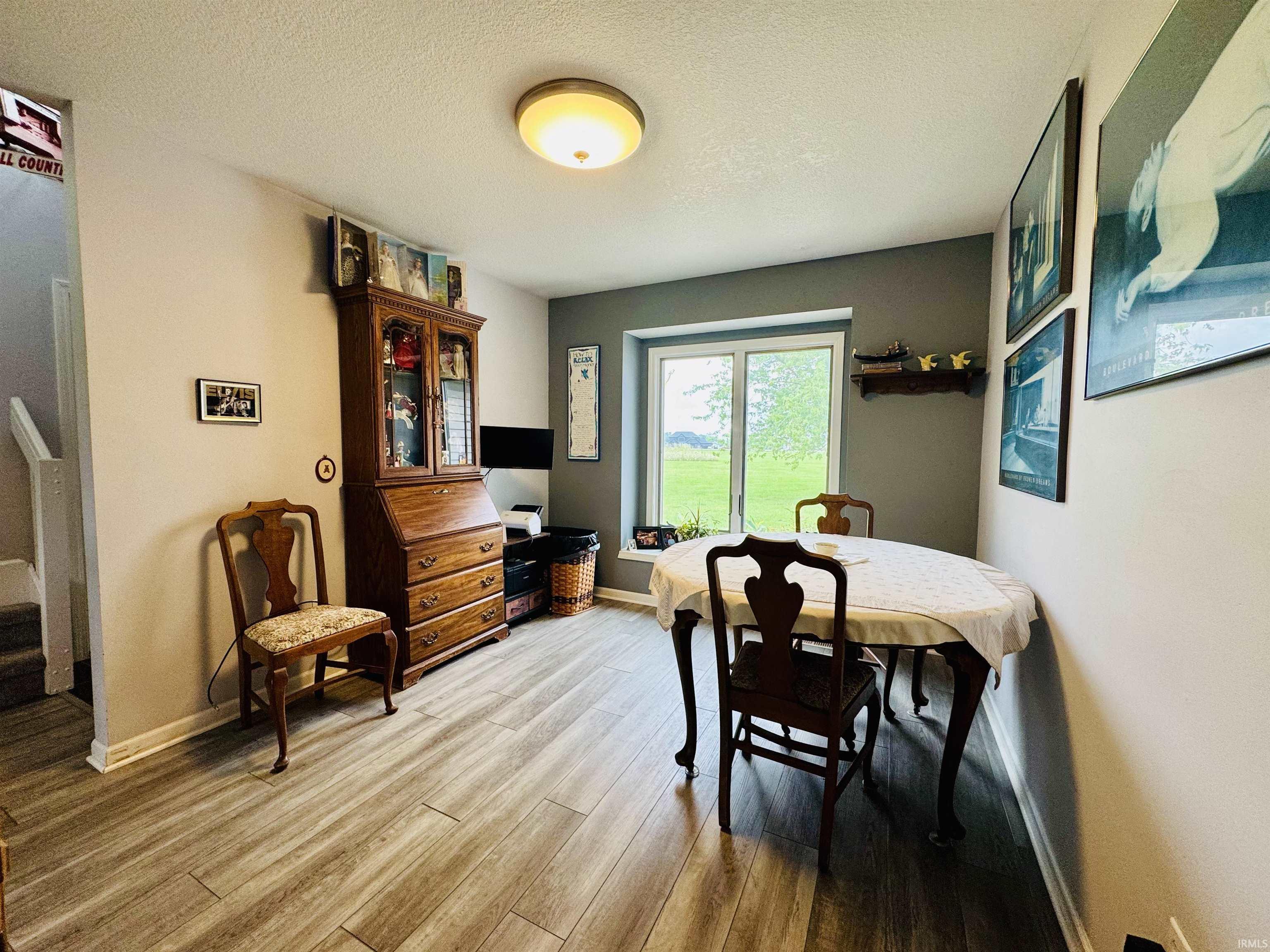 Wood-finish flooring, neutral wall tones, recessed window, and flush mount ceiling lighting