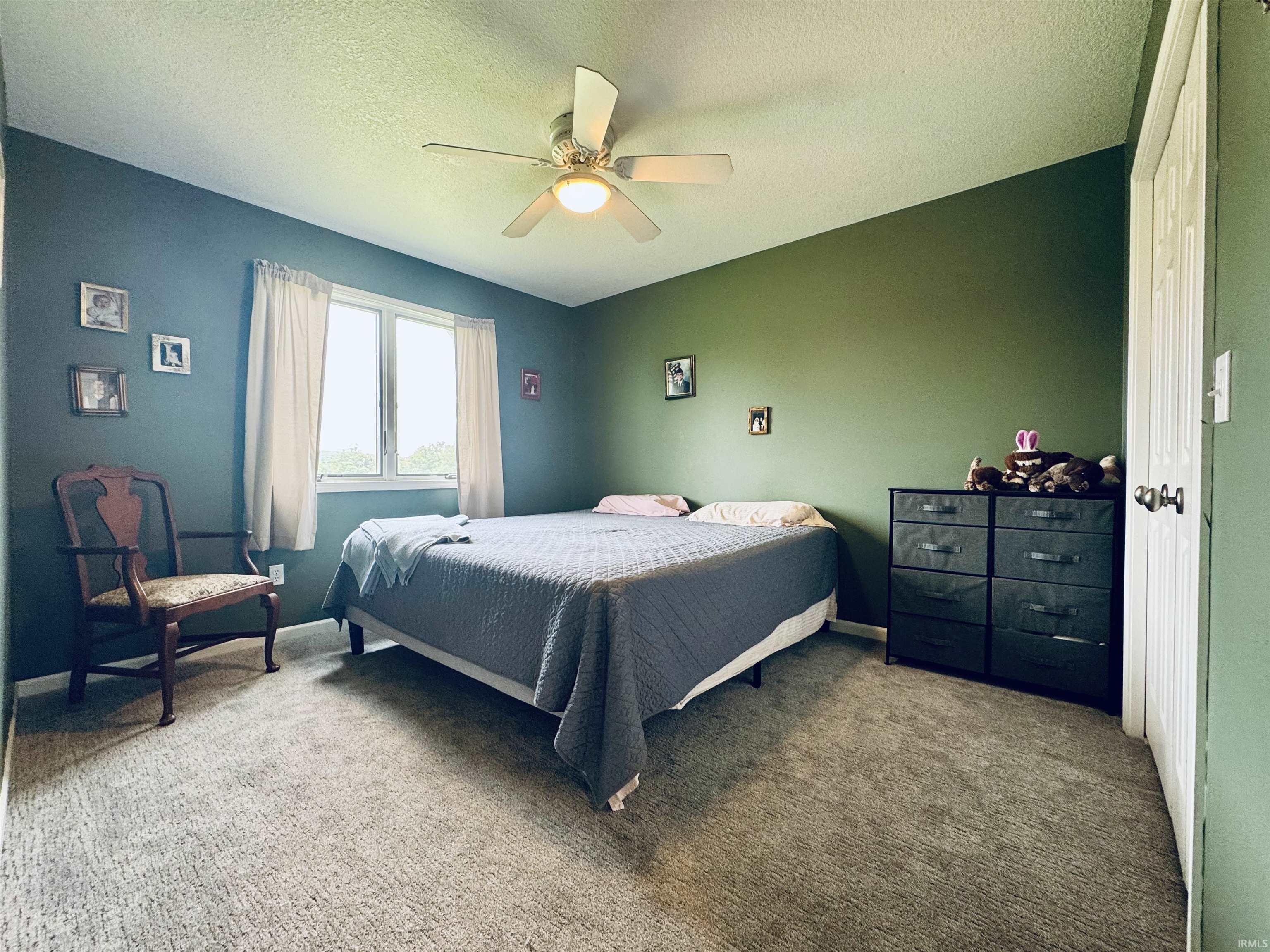 Recessed window with white trim, light-toned carpeting, and a ceiling fan with integrated lighting