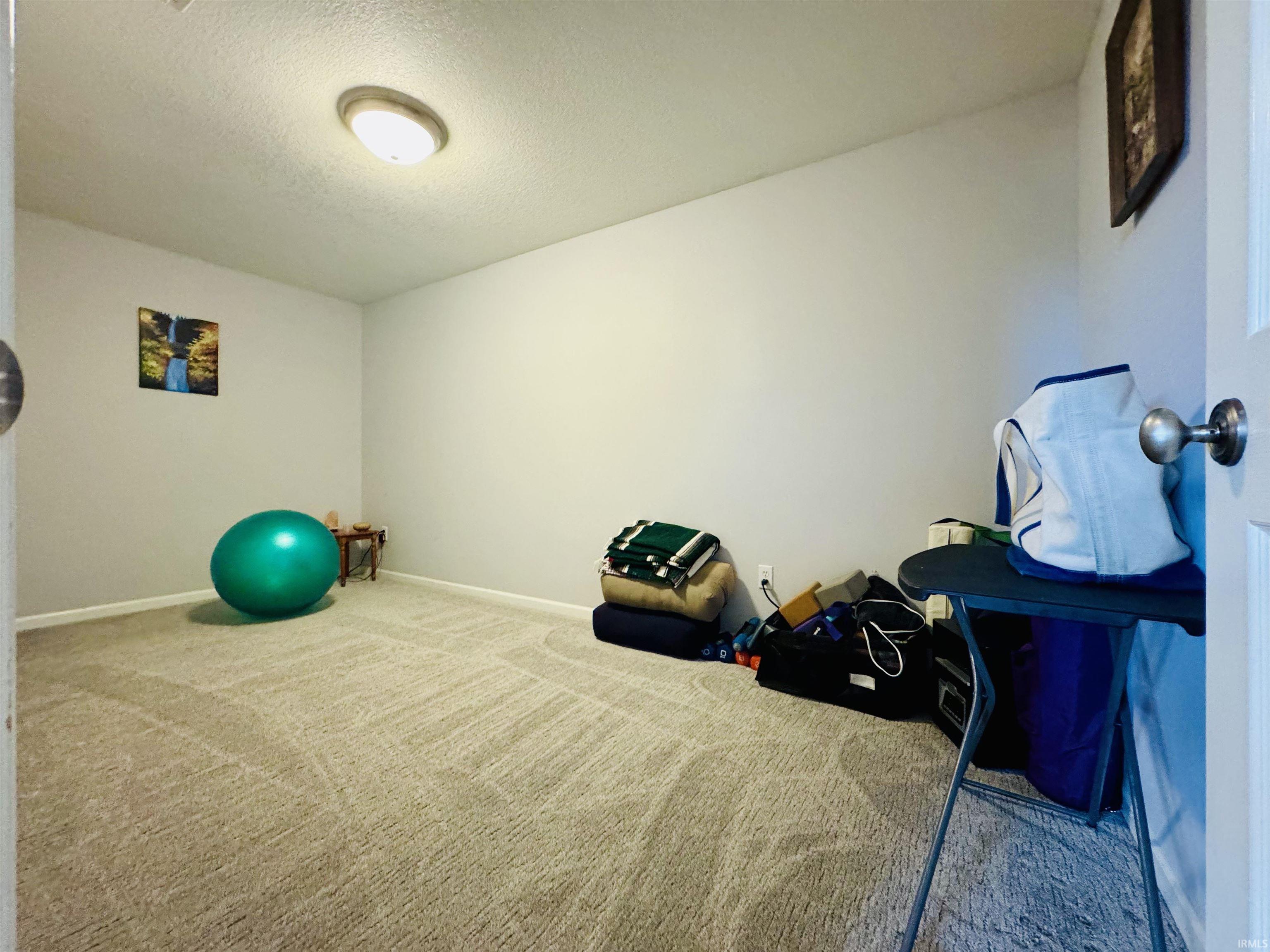 Recessed lighting fixture illuminating a carpeted room with light-colored walls