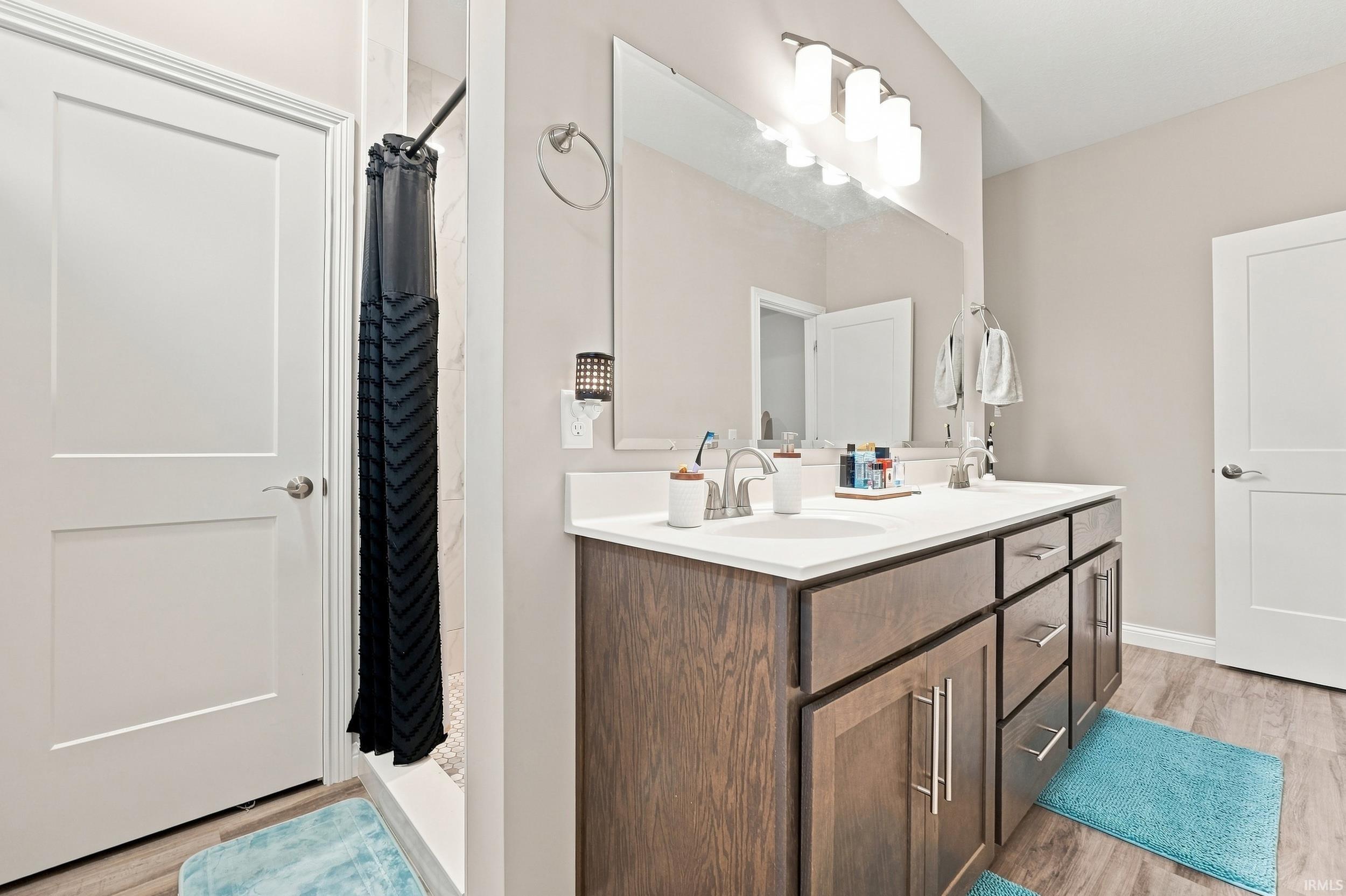 Dual vanity with a solid surface countertop, undermount sinks, and wood-finish cabinetry