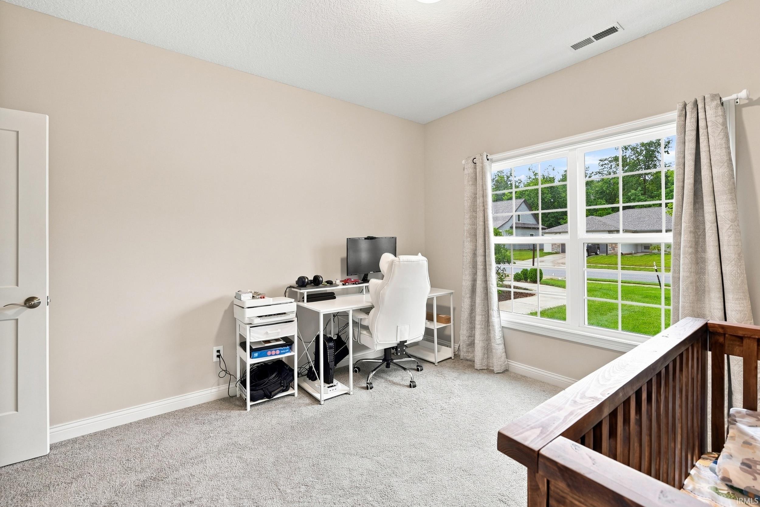 Window with multiple panes, light-colored walls, carpeted flooring, and a white interior door