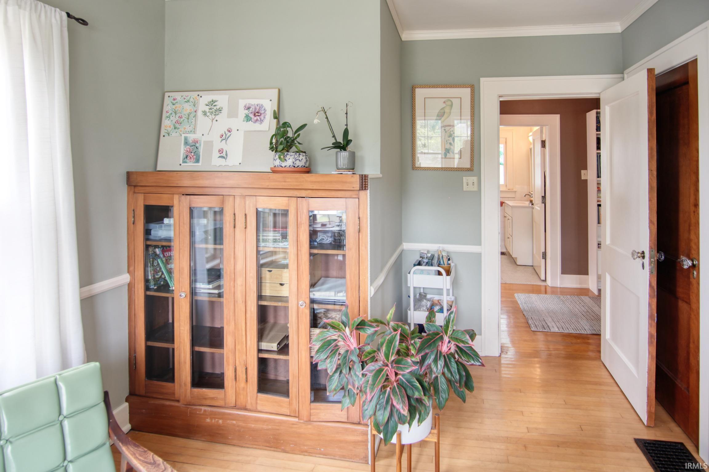 Hardwood flooring, painted interior doors, and built-in cabinetry with glass panels