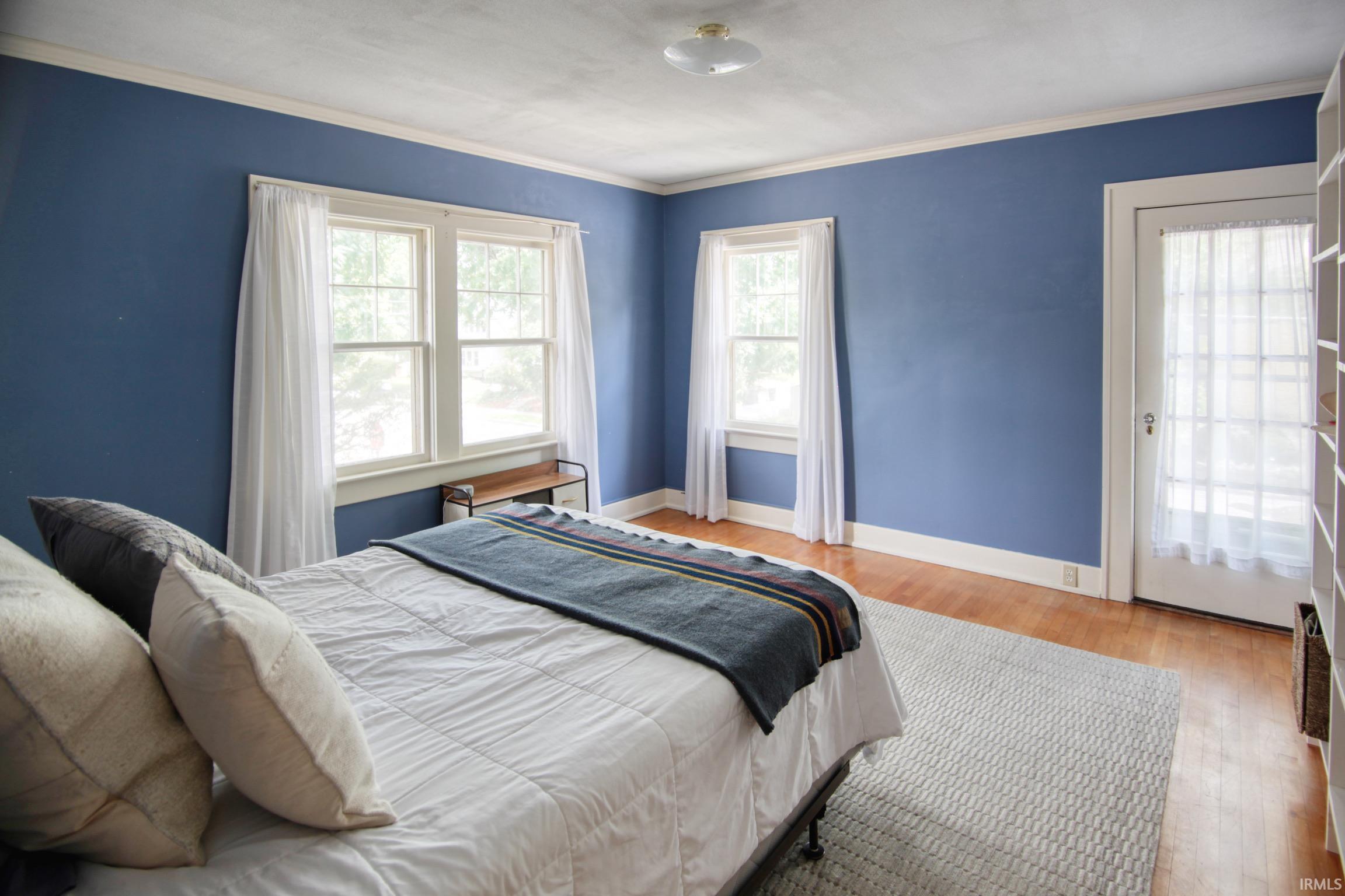 Hardwood flooring, painted walls, white trim, and a ceiling-mounted light fixture