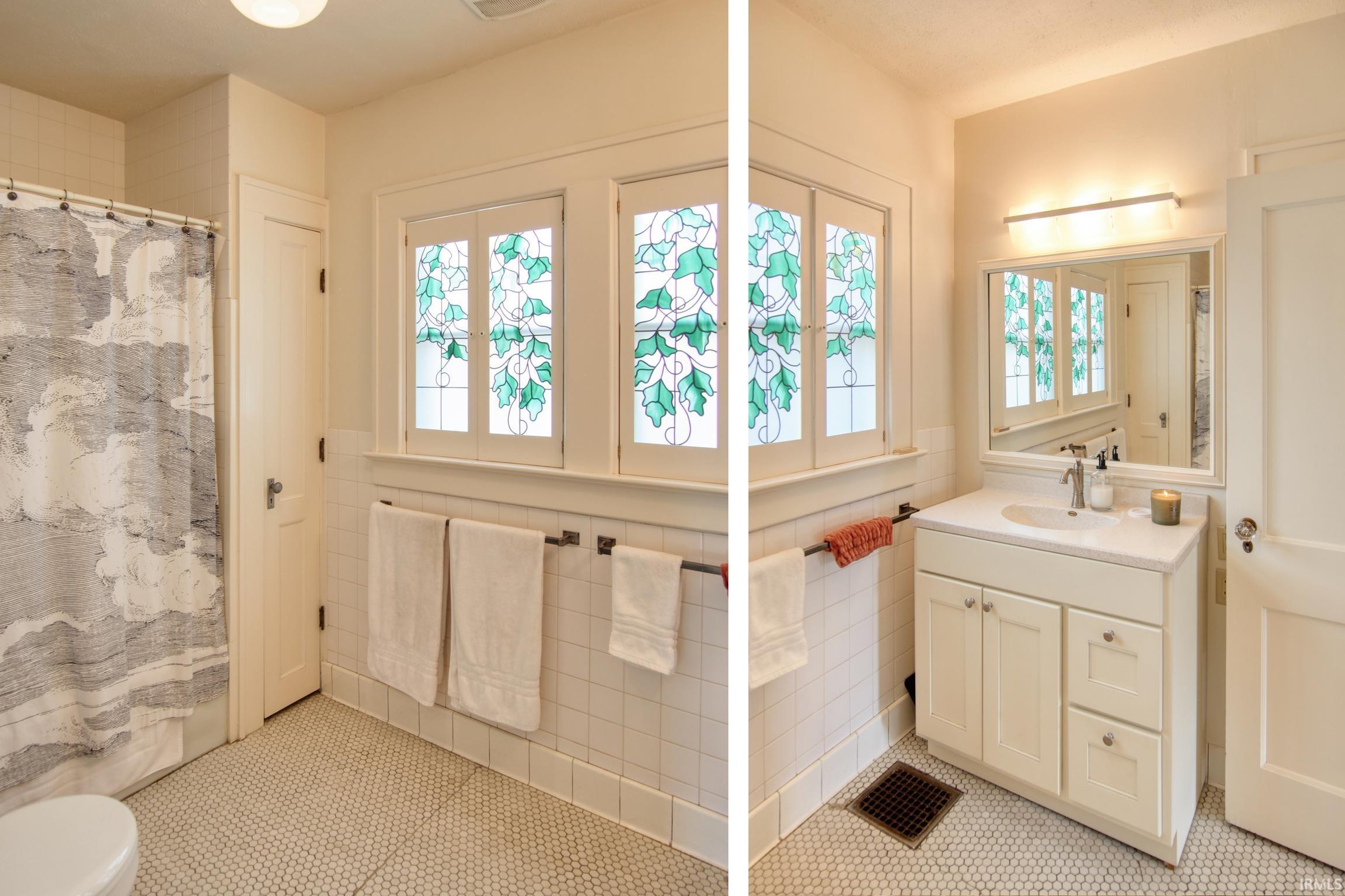 Bathroom featuring decorative stained-glass windows, white penny tile flooring, a single vanity with a white countertop, and a mirrored medicine cabinet