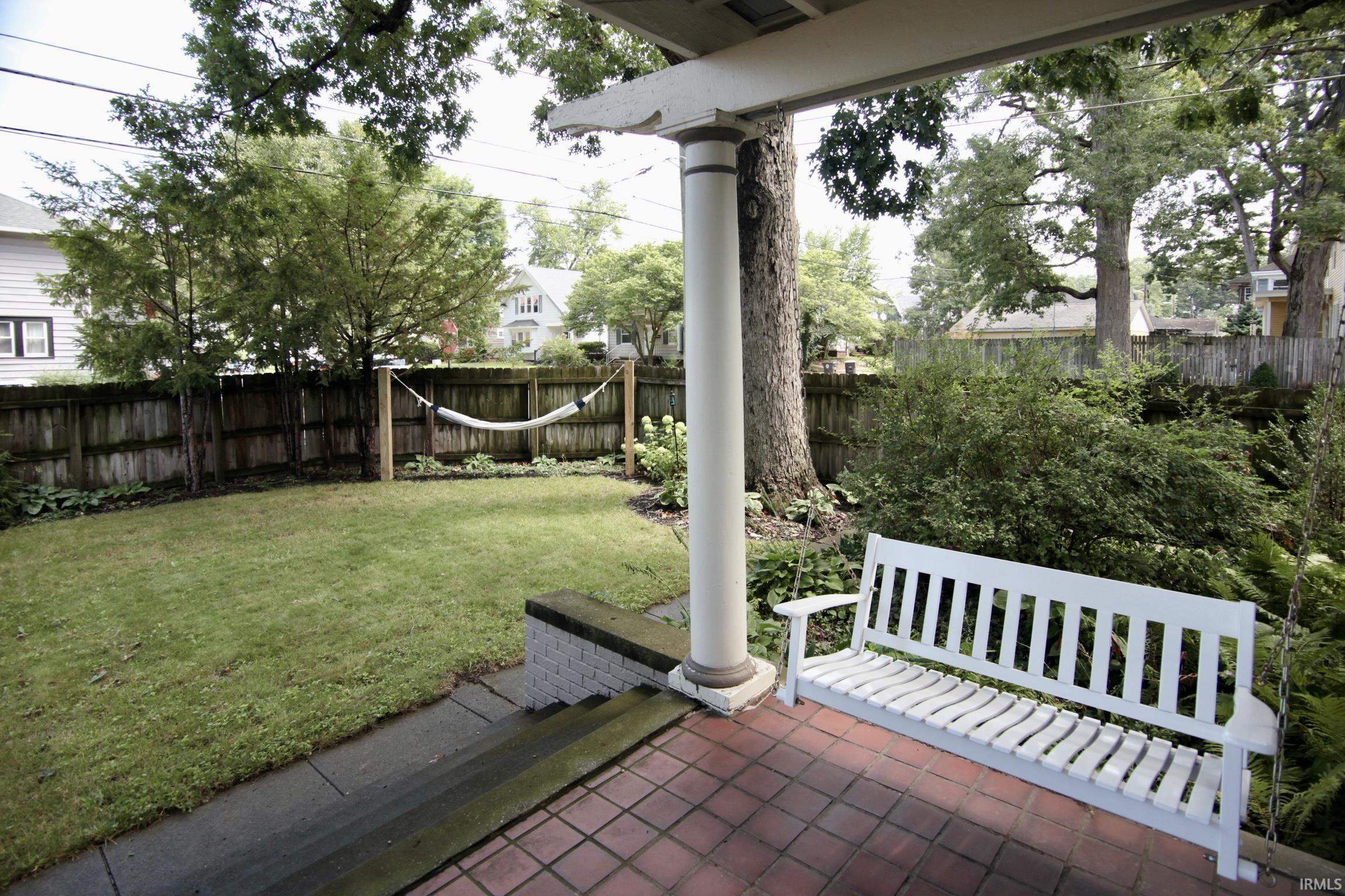 Covered porch featuring a brick paver patio