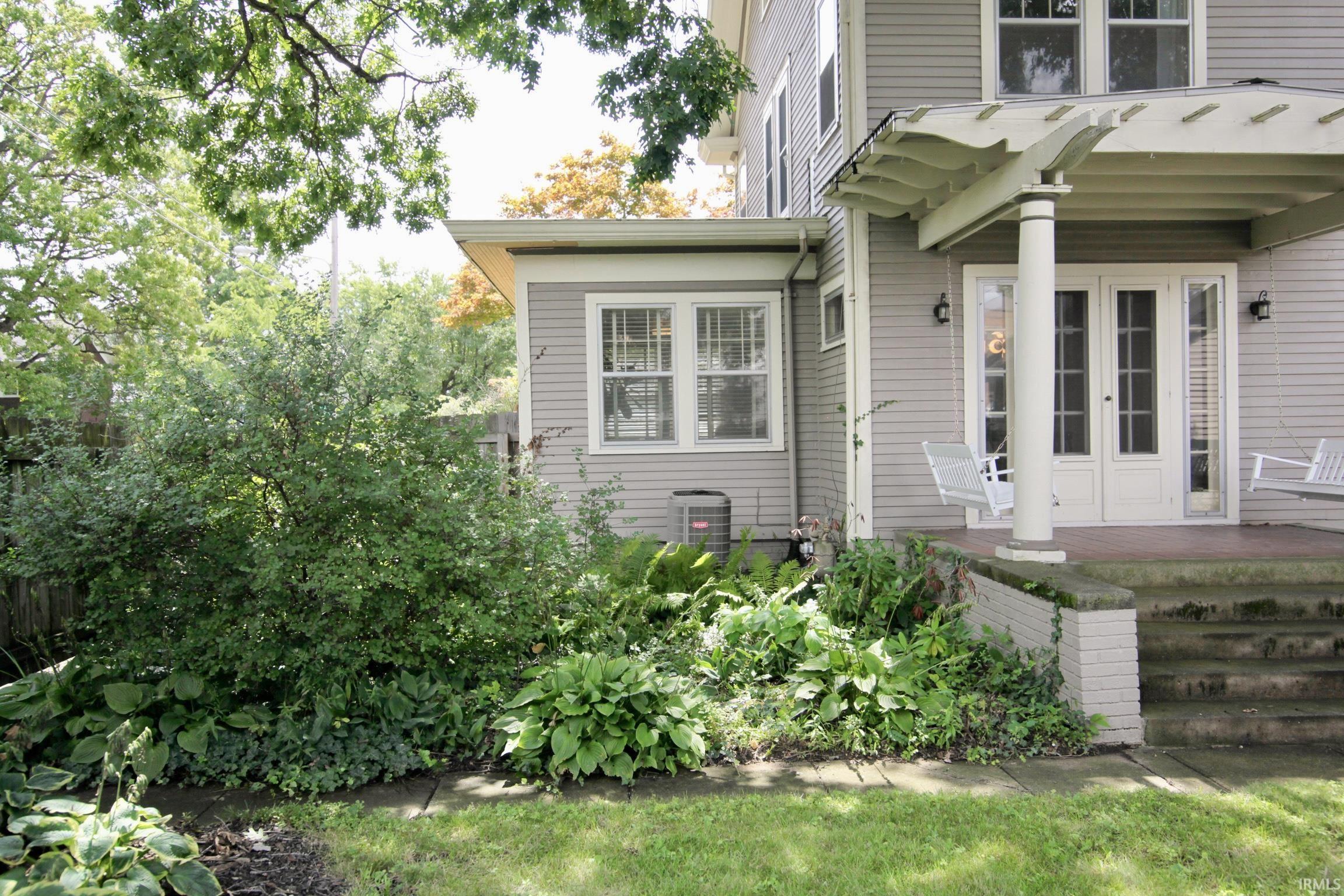 Exterior featuring horizontal siding, a covered porch with a pergola, and double French doors