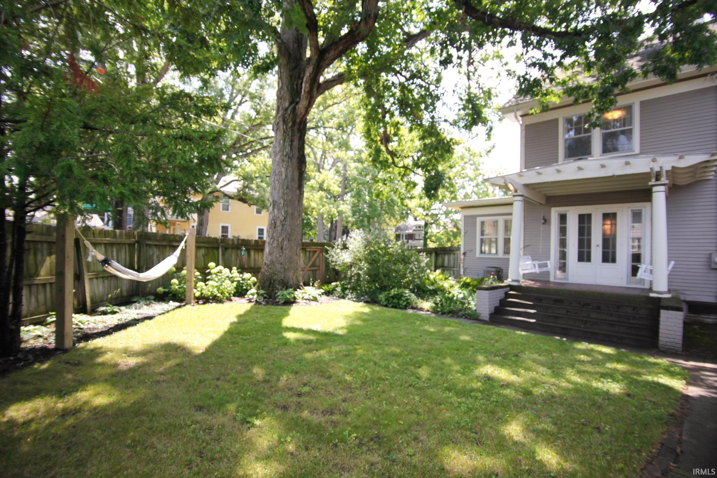 Expansive lawn with mature trees and established landscaping