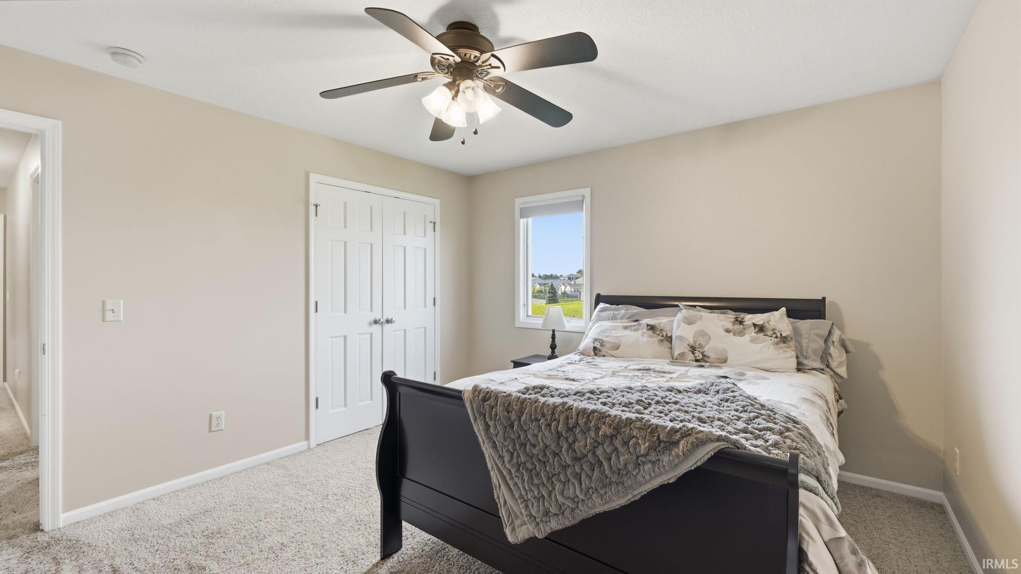 Neutral paint palette, ceiling fan with integrated lighting, carpeted flooring, white trim, and a window with natural light