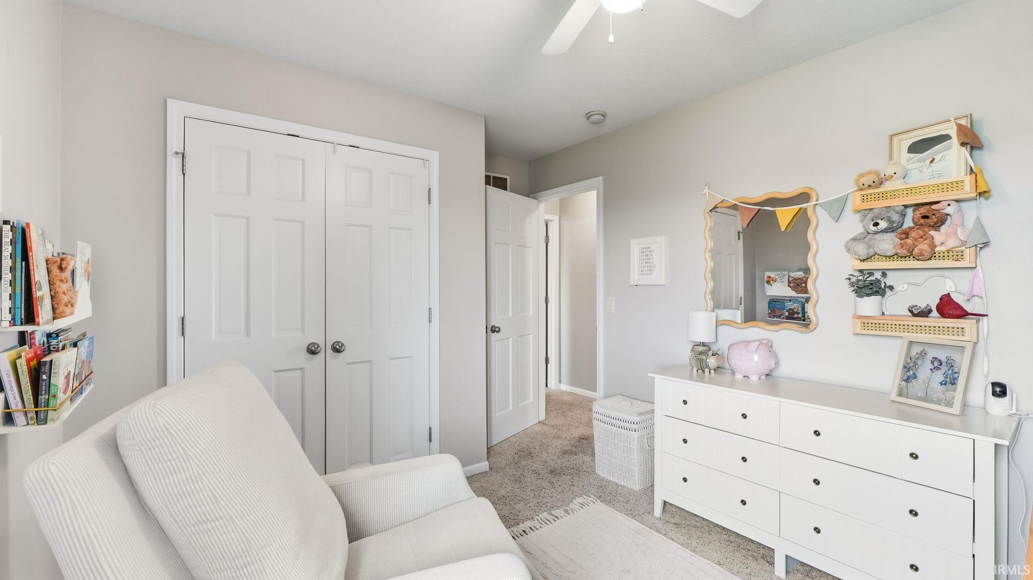 White paneled double doors, neutral painted walls, and ceiling fan with integrated lighting