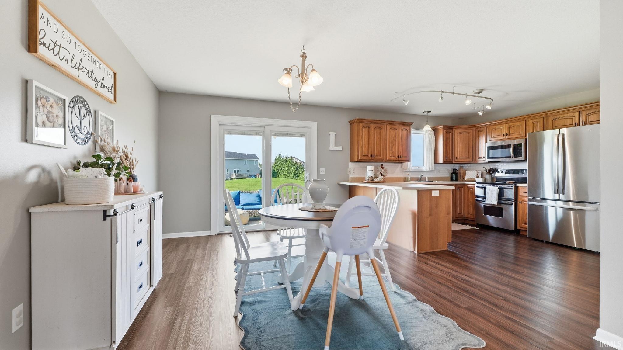 Warm wood-finish flooring extends through the dining area and kitchen