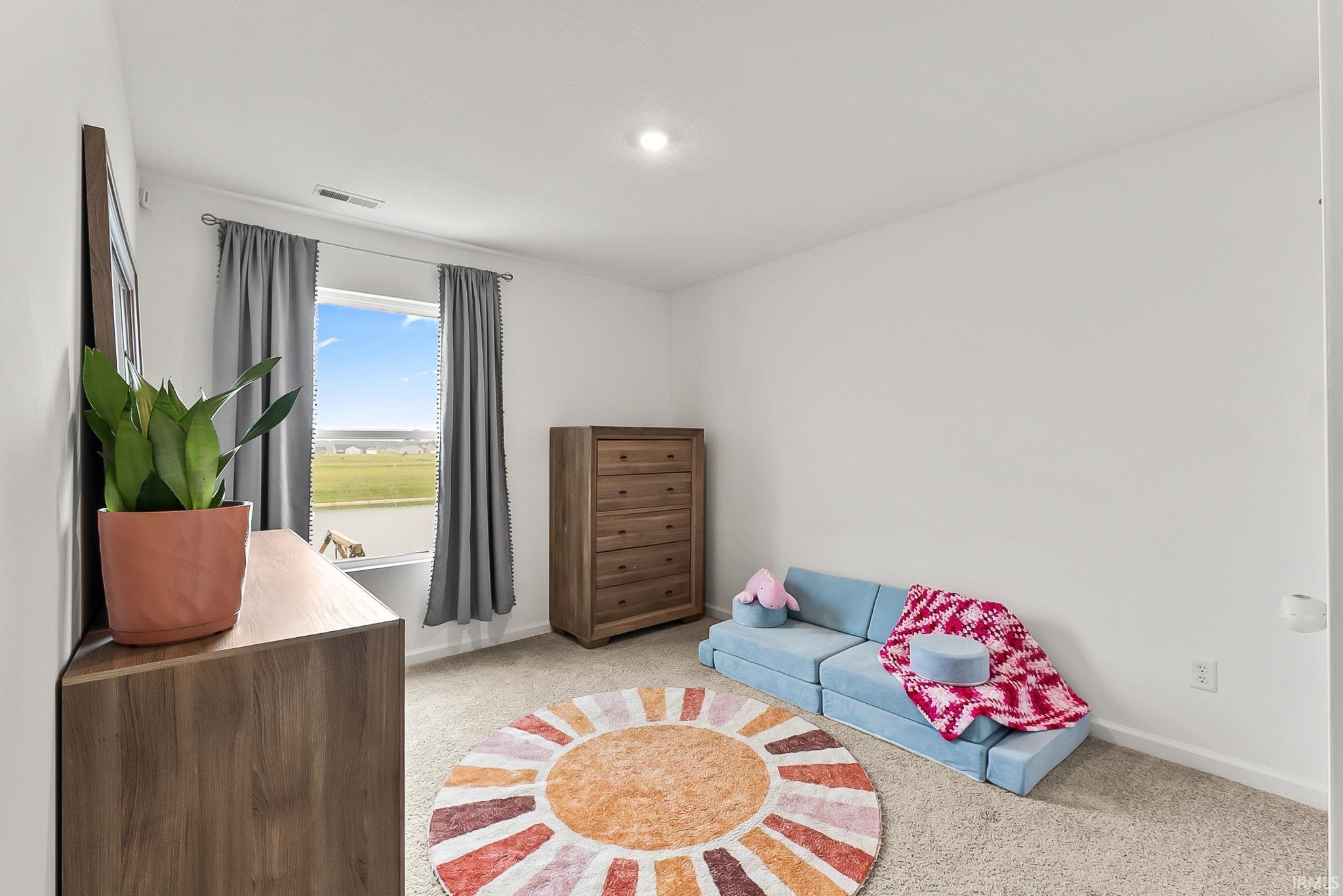 Recessed lighting, light-toned walls, and carpet flooring