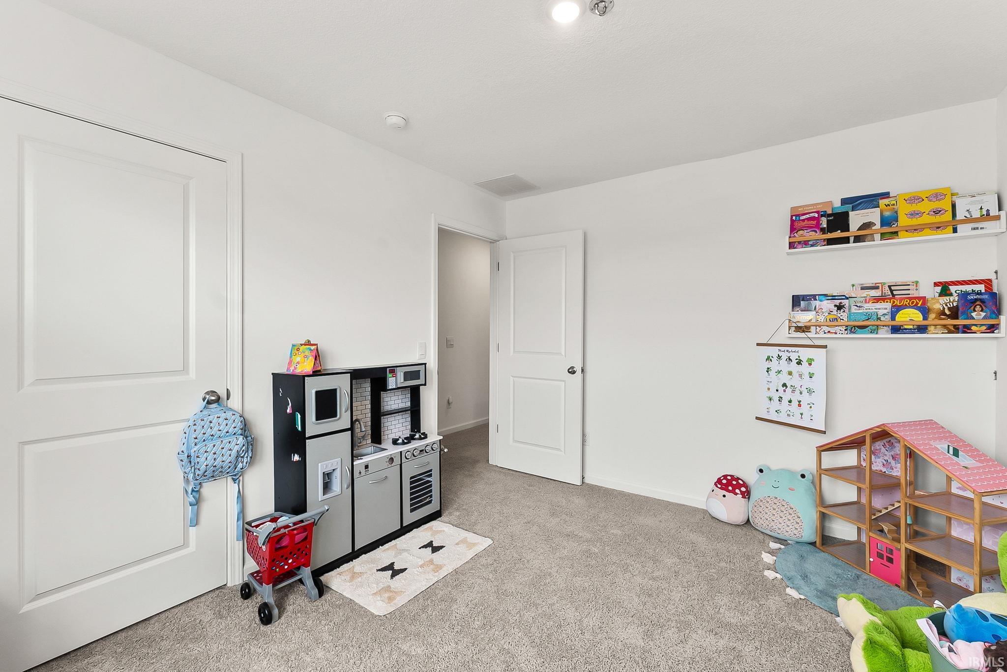 Textured carpet flooring, white walls, two panel interior doors, recessed lighting, and wall-mounted shelving