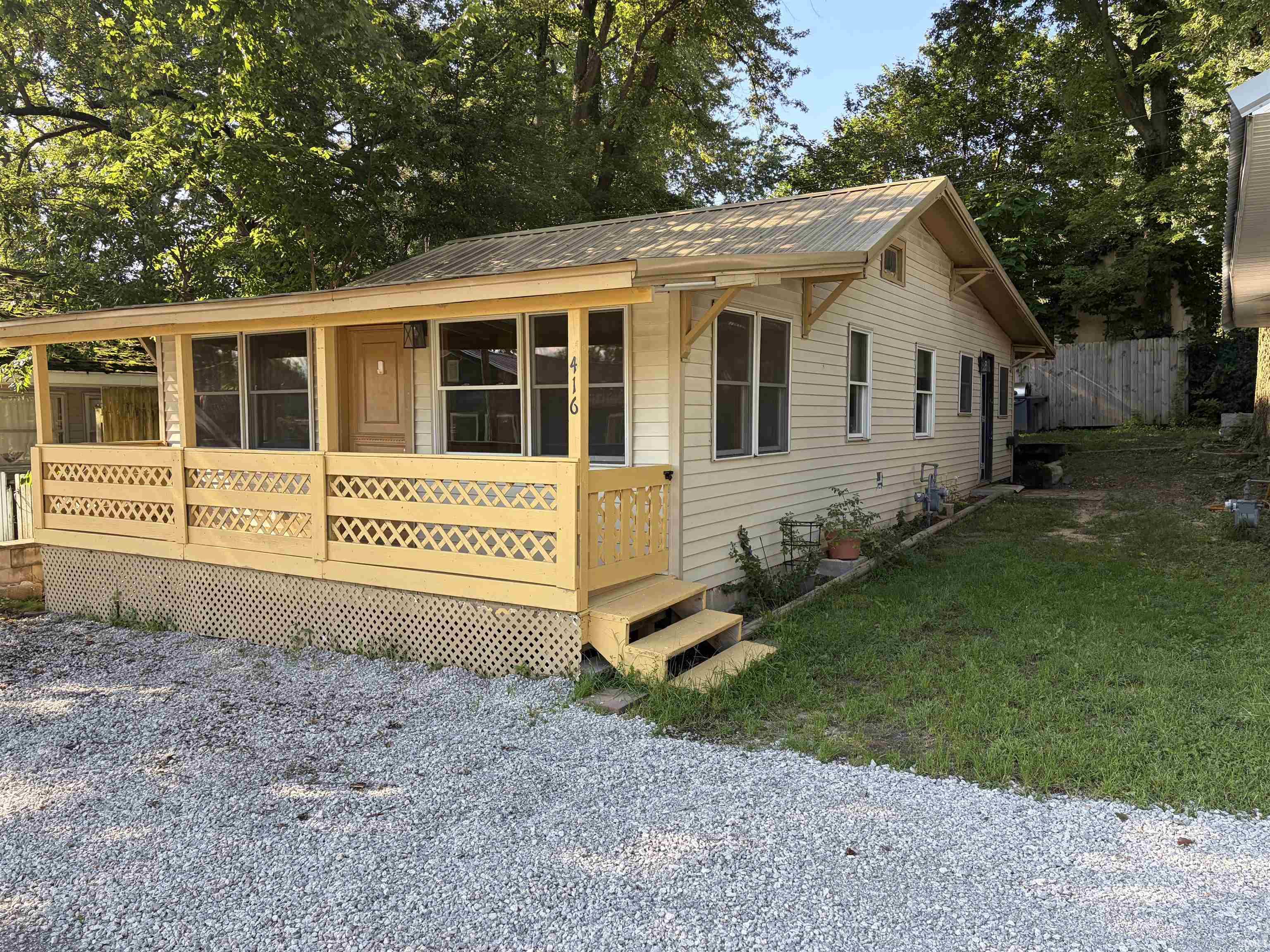 Siding exterior with a metal roof and a covered porch