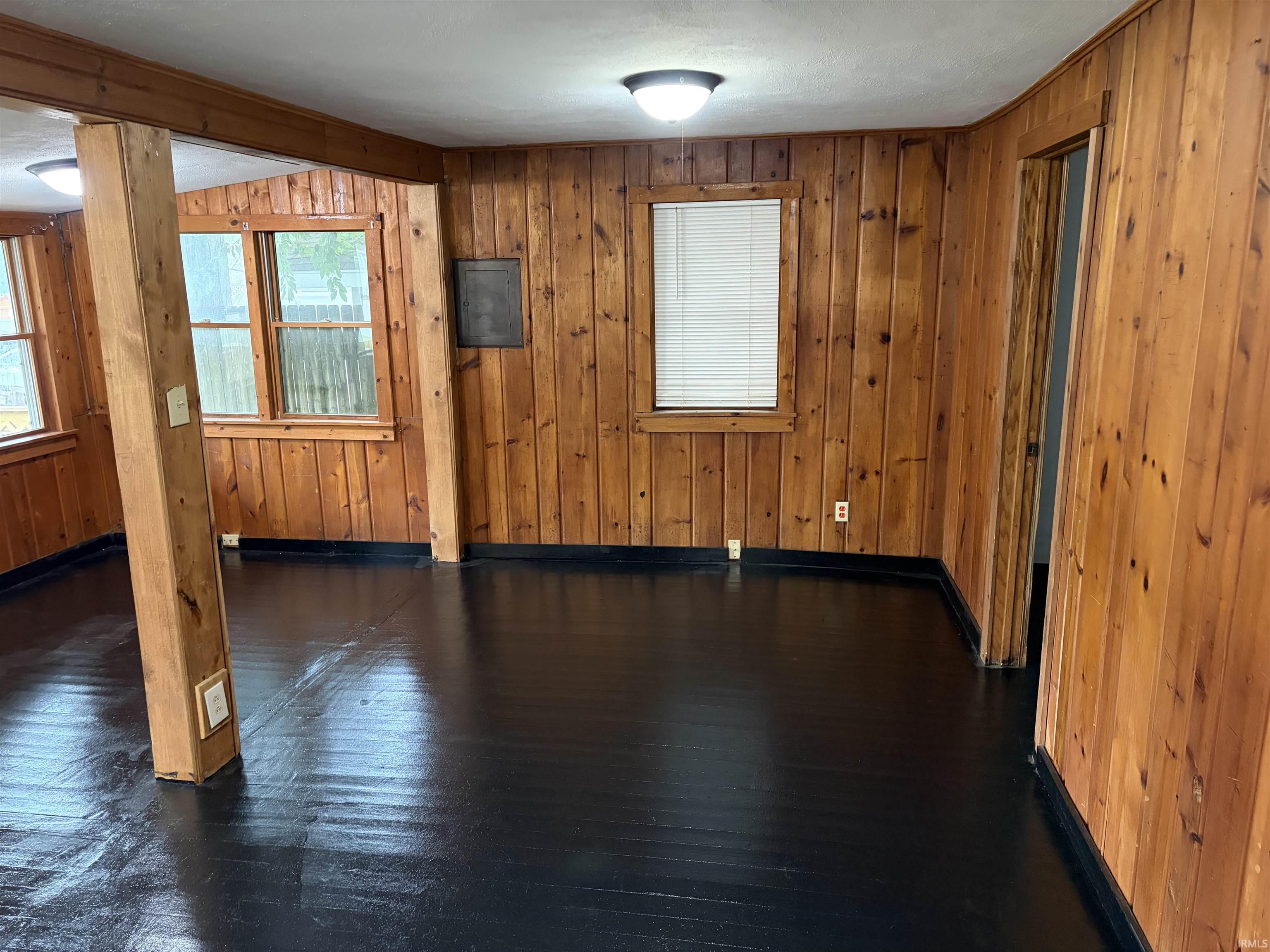 Wood paneling throughout, black-painted flooring, and ceiling-mounted light fixtures
