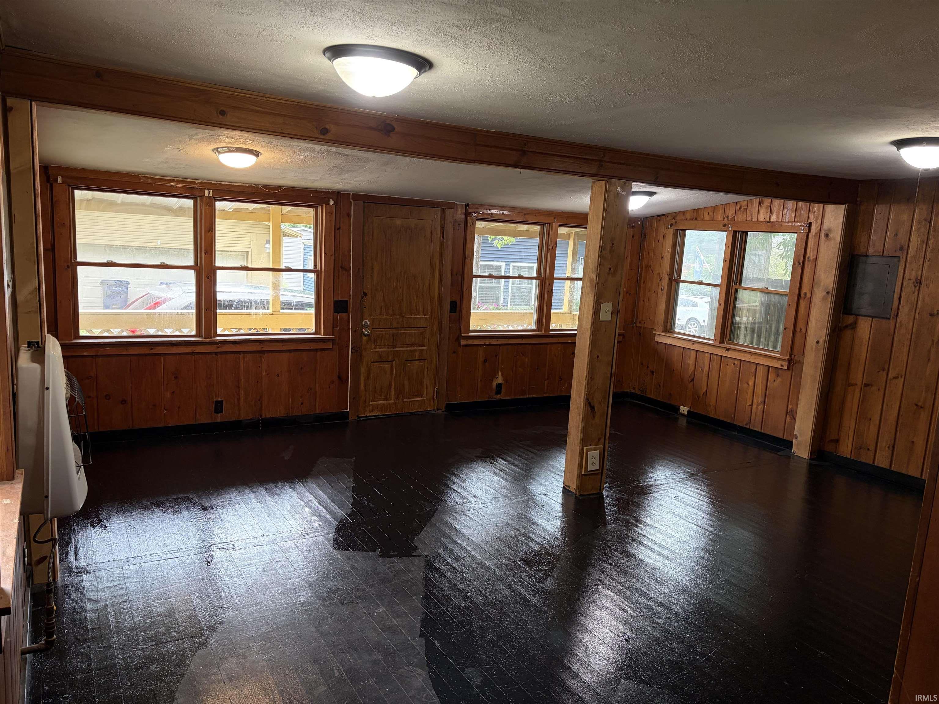 Wood-paneled walls and exposed wood beams frame this room