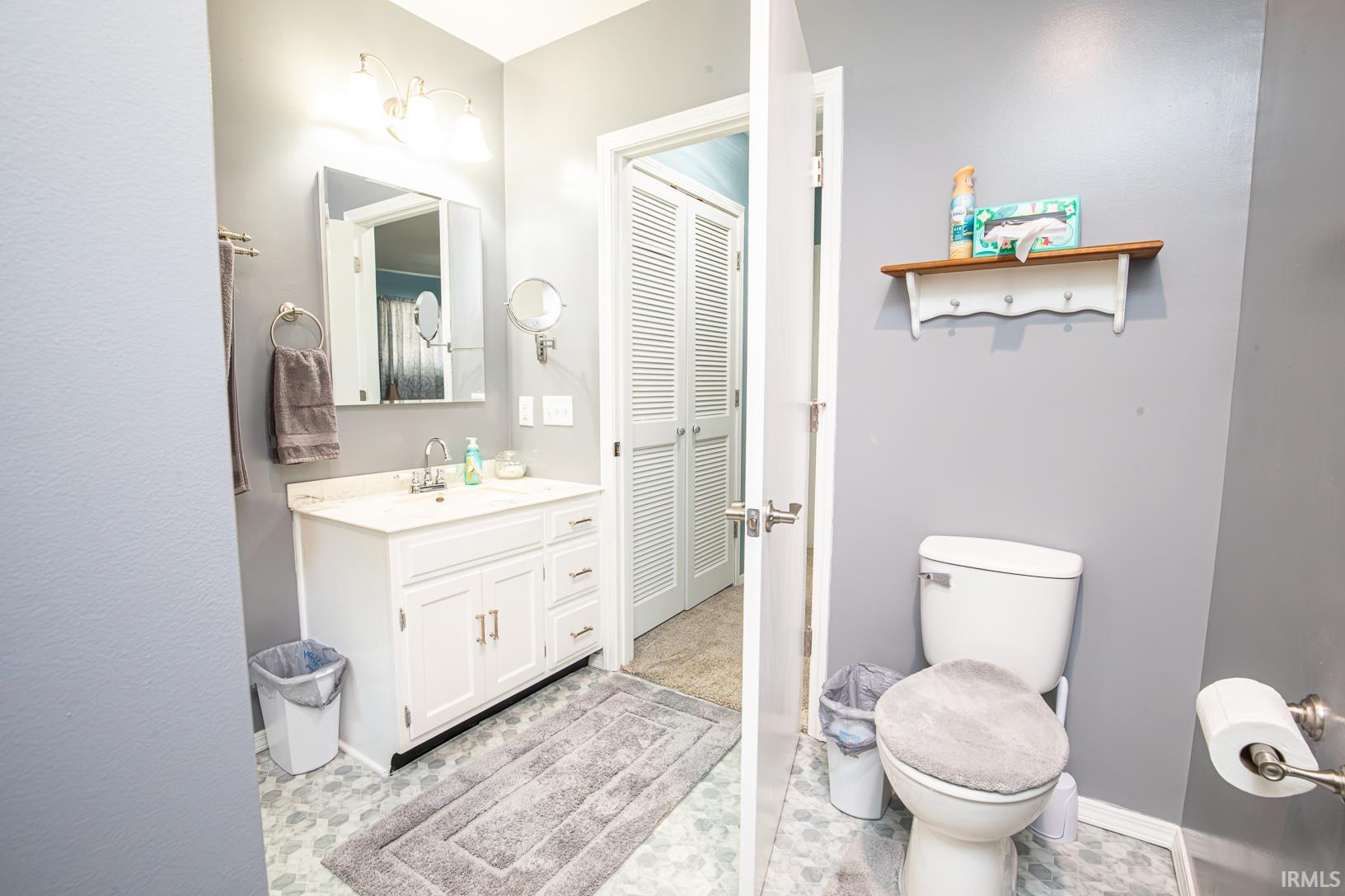 Bathroom featuring a white vanity with an integrated sink, polished chrome faucet, and a wall-mounted mirror