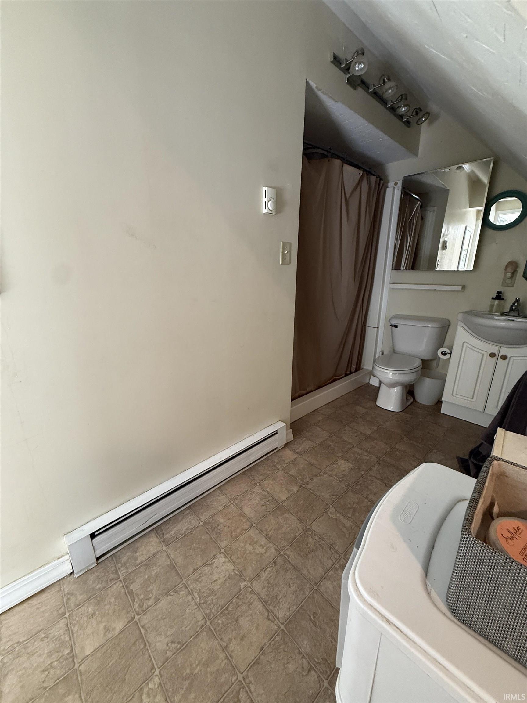Bathroom featuring a vanity with an integrated sink, track lighting, and a toilet