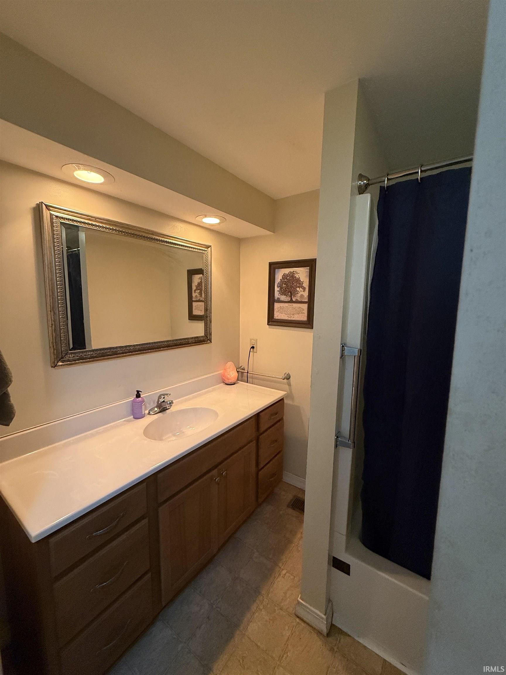 Extended vanity with an integrated sink and wood-finish cabinetry