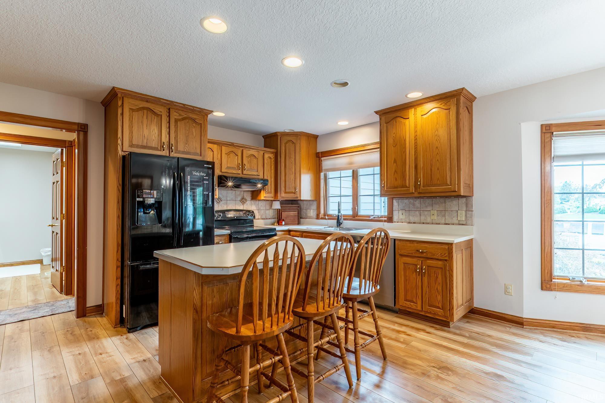 Kitchen featuring wood-finish flooring, recessed lighting, and wood cabinetry