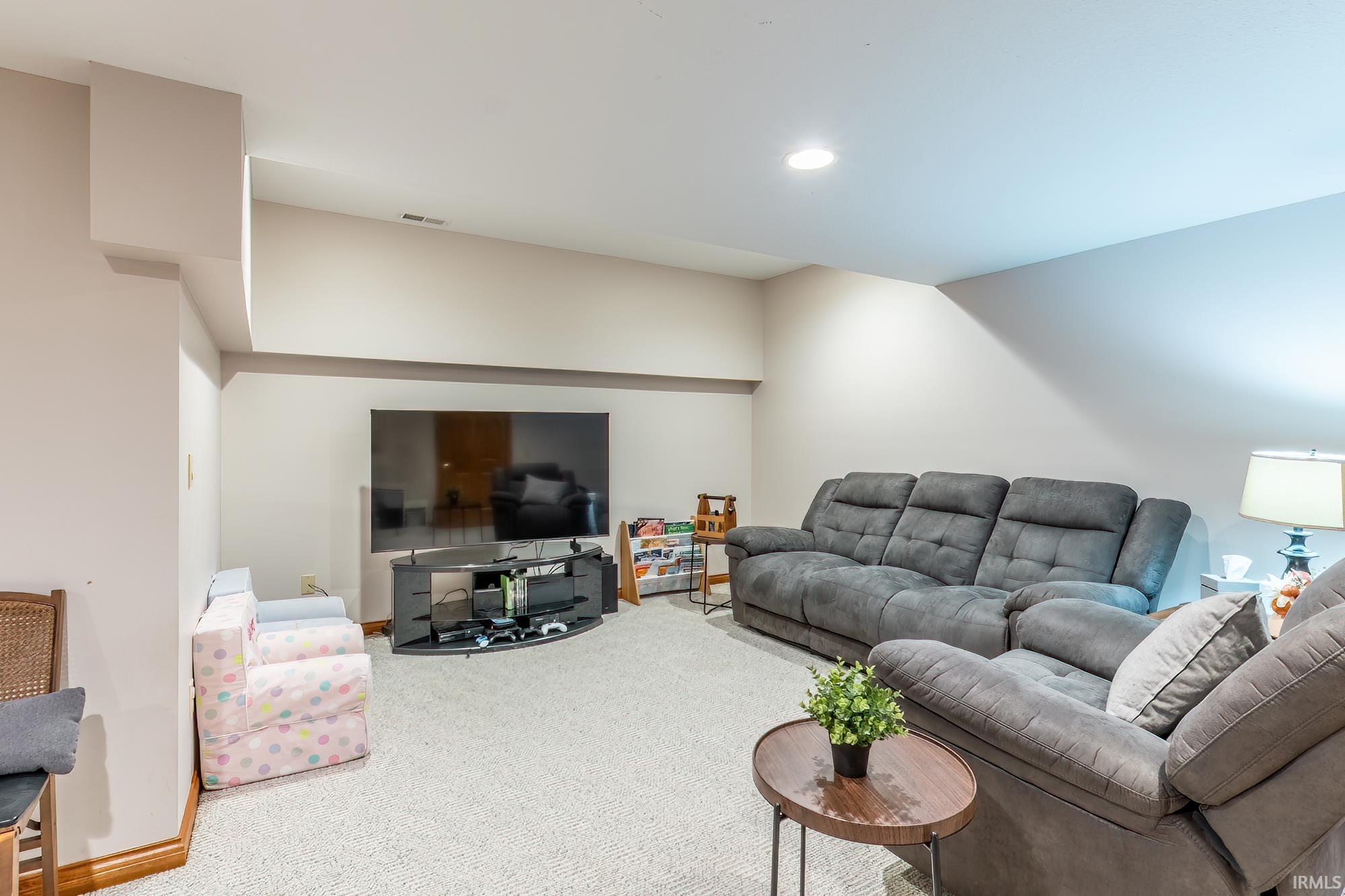 Recessed ceiling lighting, light-toned carpeting, and neutral wall tones
