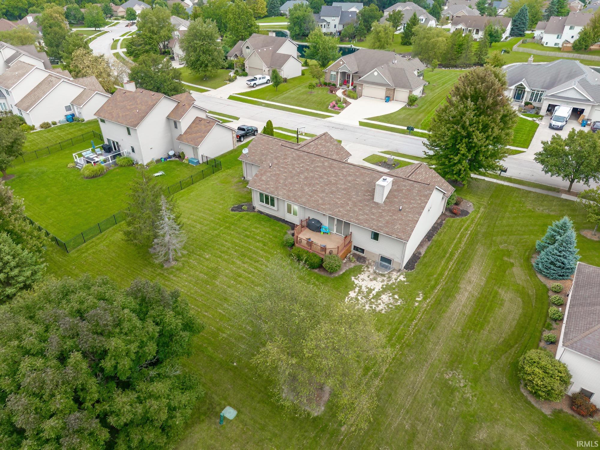Expansive property featuring a multi-level structure, a large rear deck, and a spacious green lawn