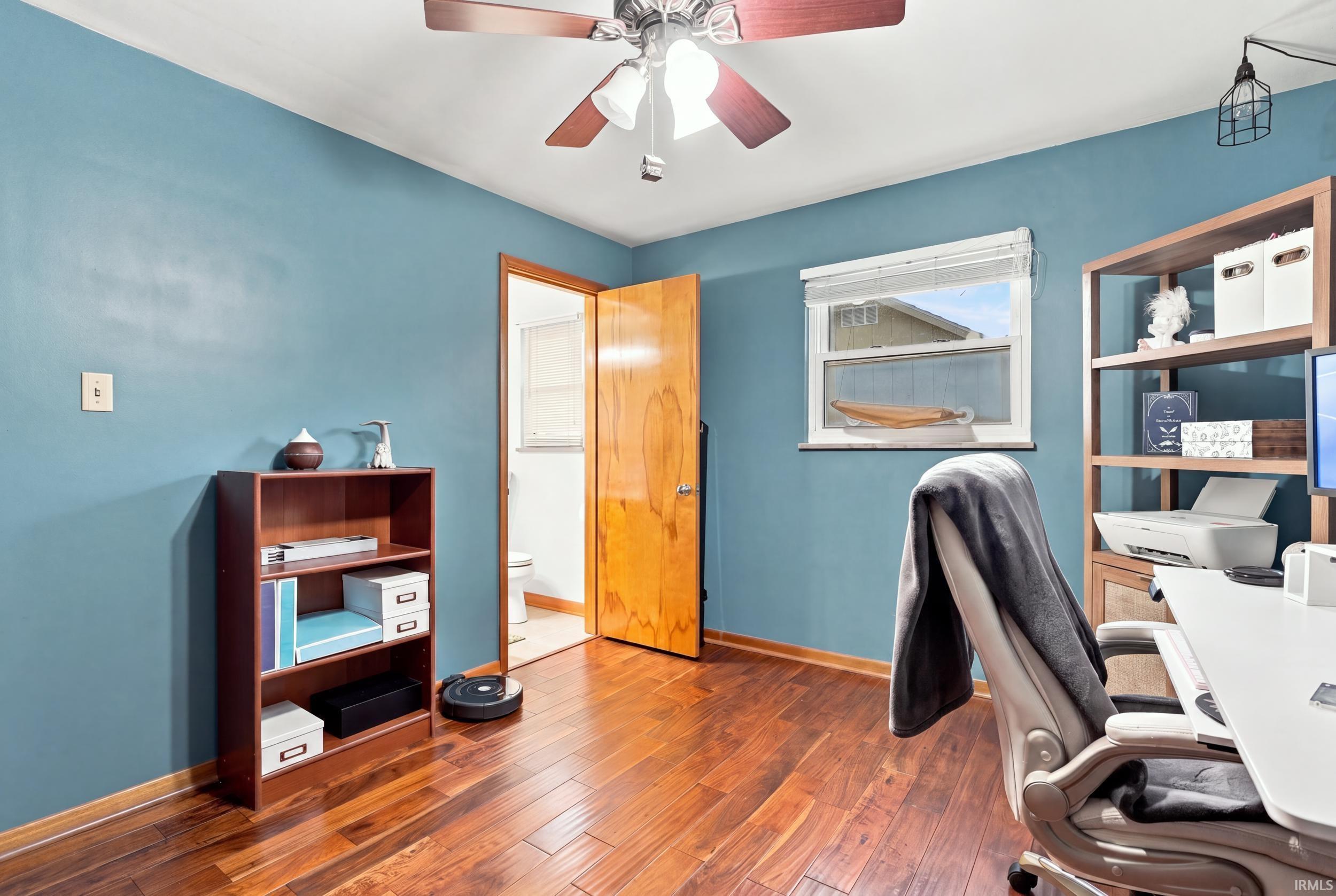 Room featuring wood-finish flooring, a ceiling fan, and a single window