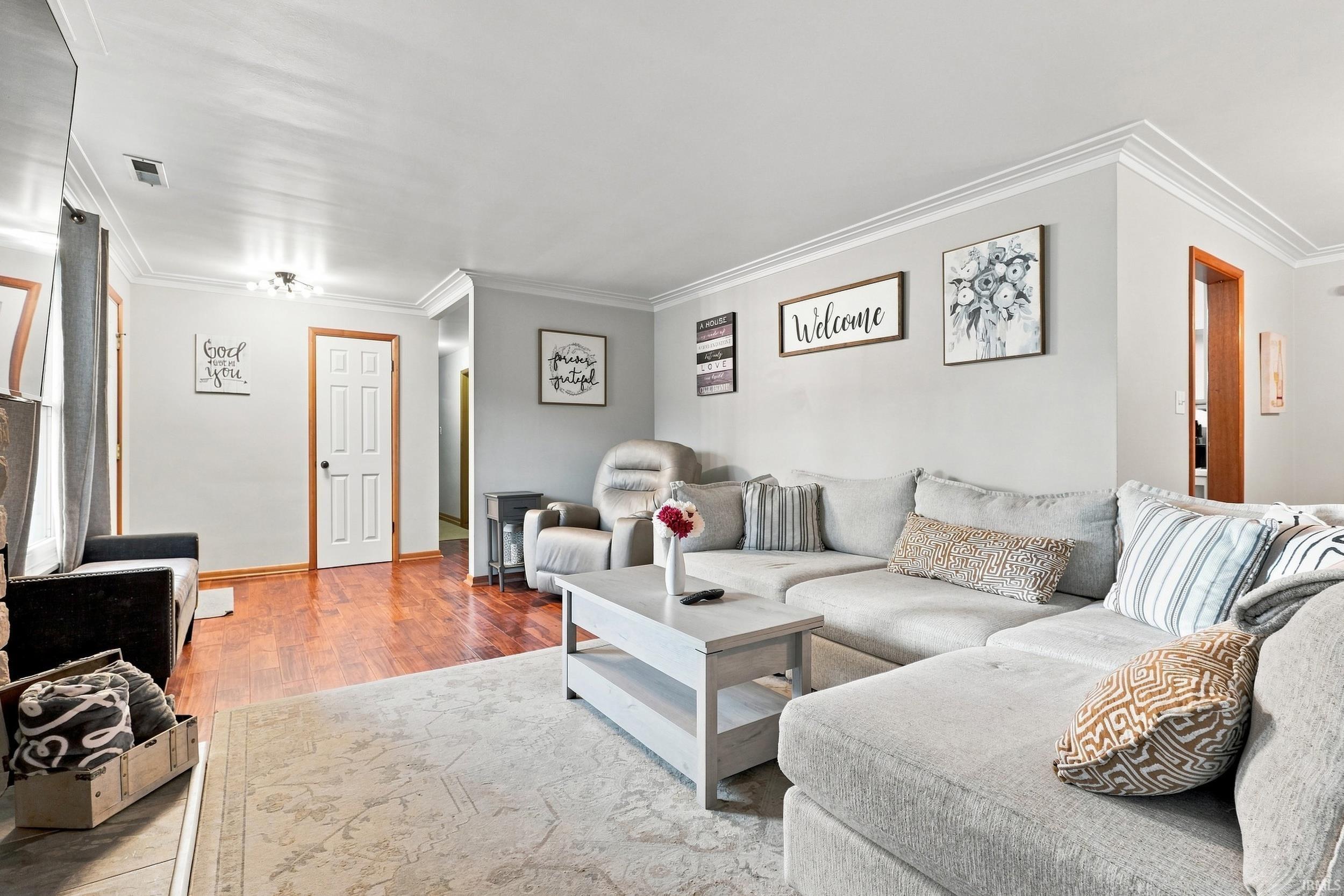 Living area featuring crown molding, recessed lighting, wood-finish flooring, and light wall tones