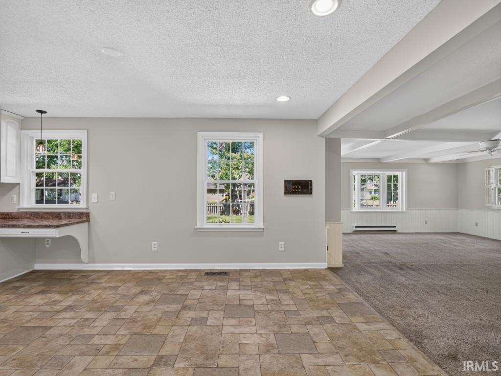 Recessed lighting, tiled flooring, white cabinetry, a built-in countertop, and exposed ceiling beams