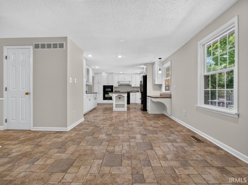 Spacious room with patterned tile-style flooring